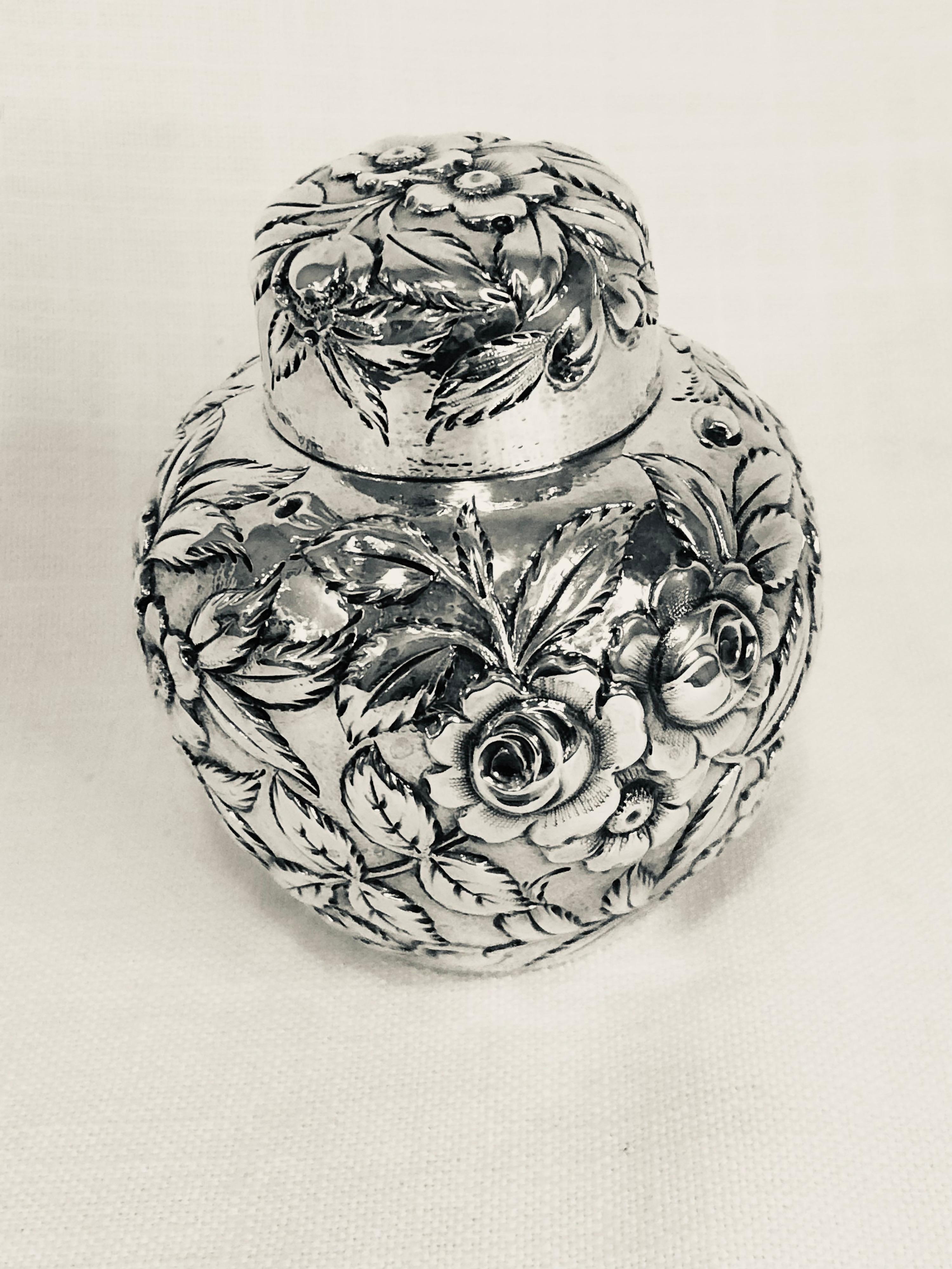 I am offering you this beautiful and rare S. Kirk & Son sterling silver tea caddy. It is covered with a repousse decoration of flowers and leaves on all its sides and on its cover. You can see the beautiful repousse pattern in the pictures. On the