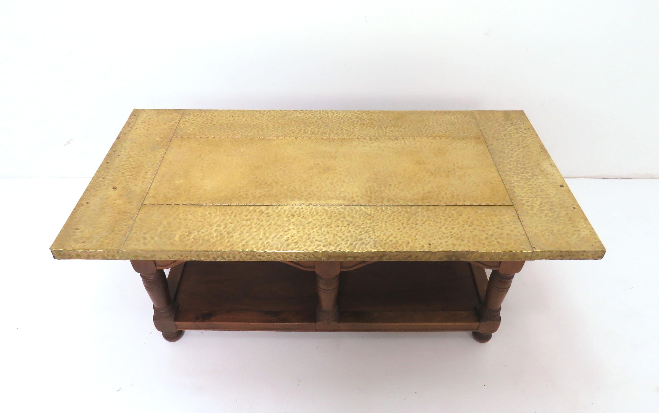 A Spanish Colonial style coffee table by Sarreid Ltd, with a brass clad and studded top, over a trestled walnut base.