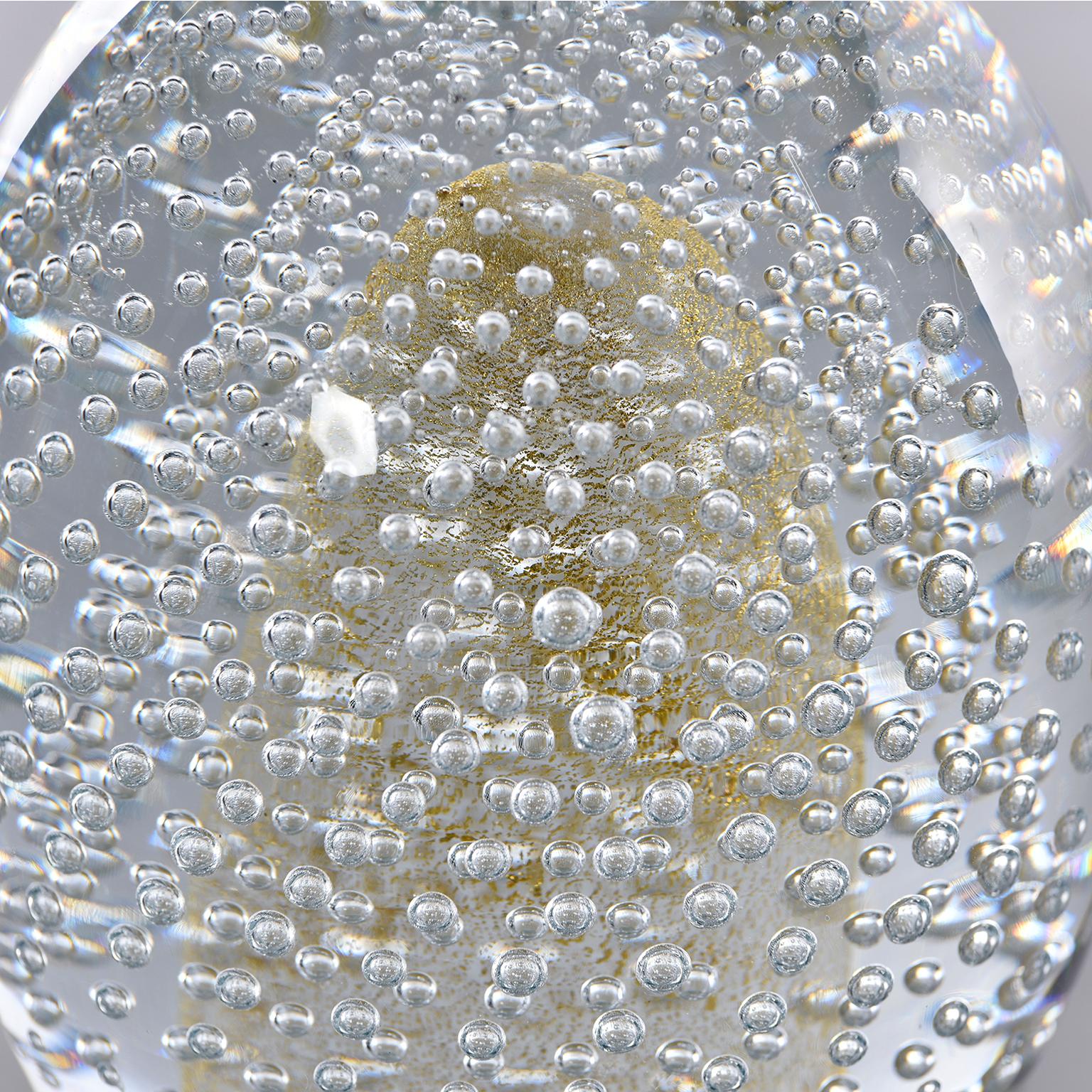 Seguso egg shaped paper weight in clear heavy glass with bubbles and gold inclusions, circa 1980s. Etched signature on underside of base.