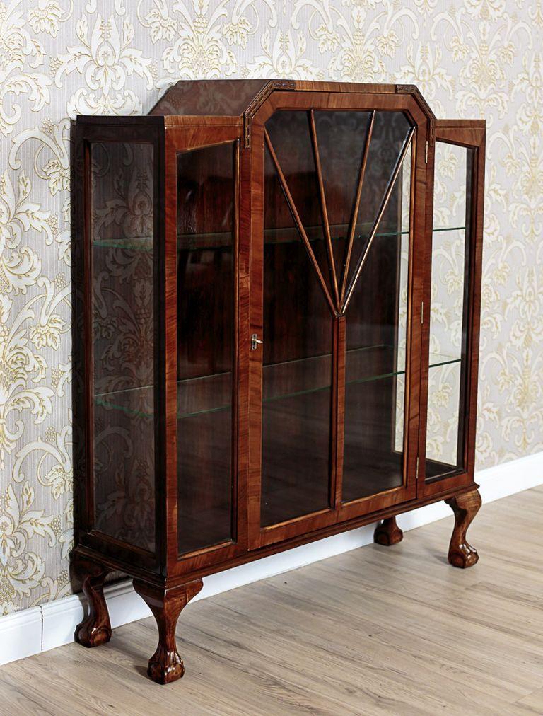 A piece of furniture with a signature of B&E Strump Manufactory from Glasgow.
The showcase is of simple, geometrical shapes, and is glazed on three sides.
The three-door, main segment is supported on legs in the shape of a sphere within bird