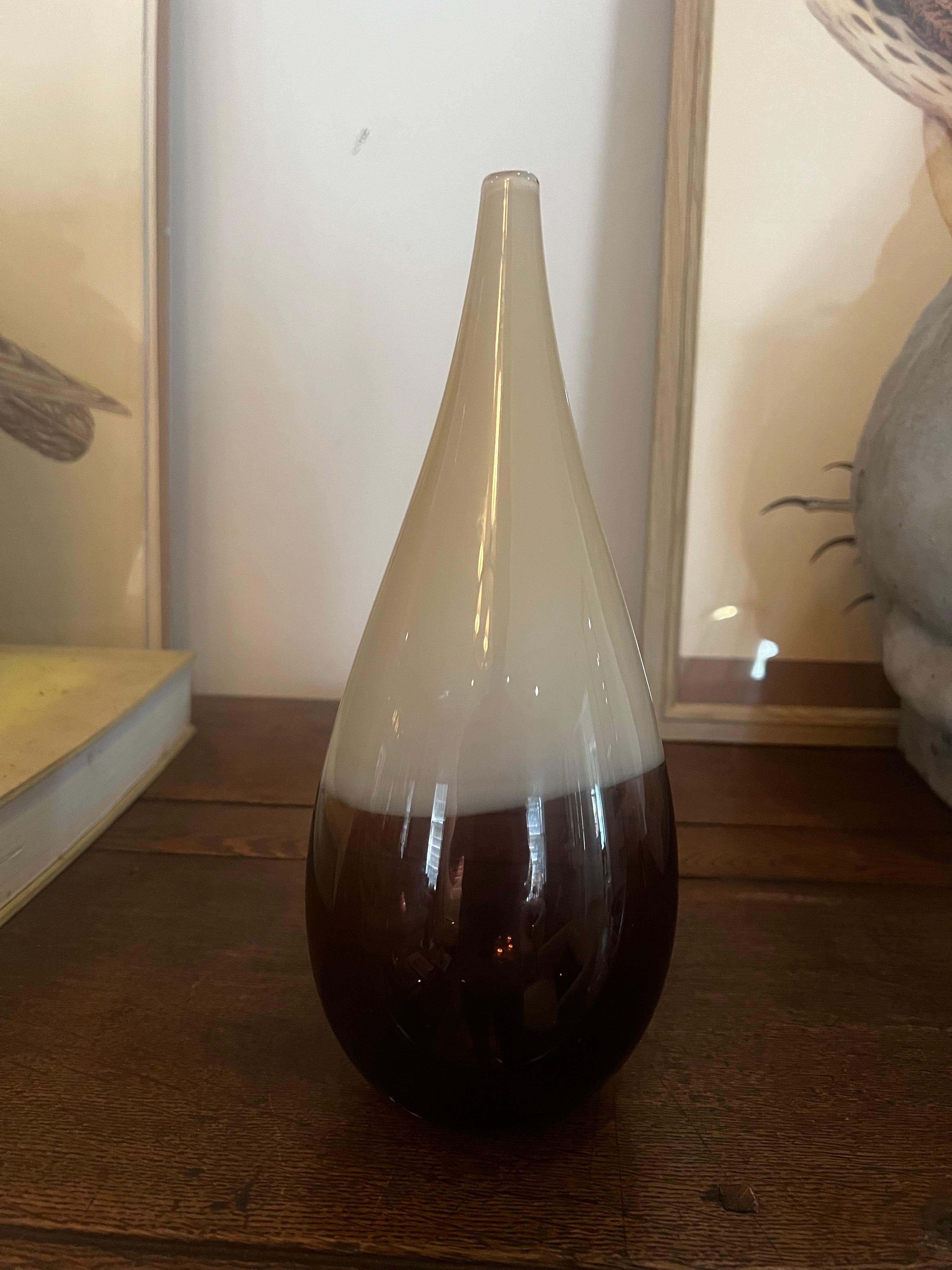 Hand blown and shaped in lead free crystal.  Murano inspired glass with transparent off white and amber layers.   
11” H
Signed 2004 by Caleb Siemon.  Made in California.  