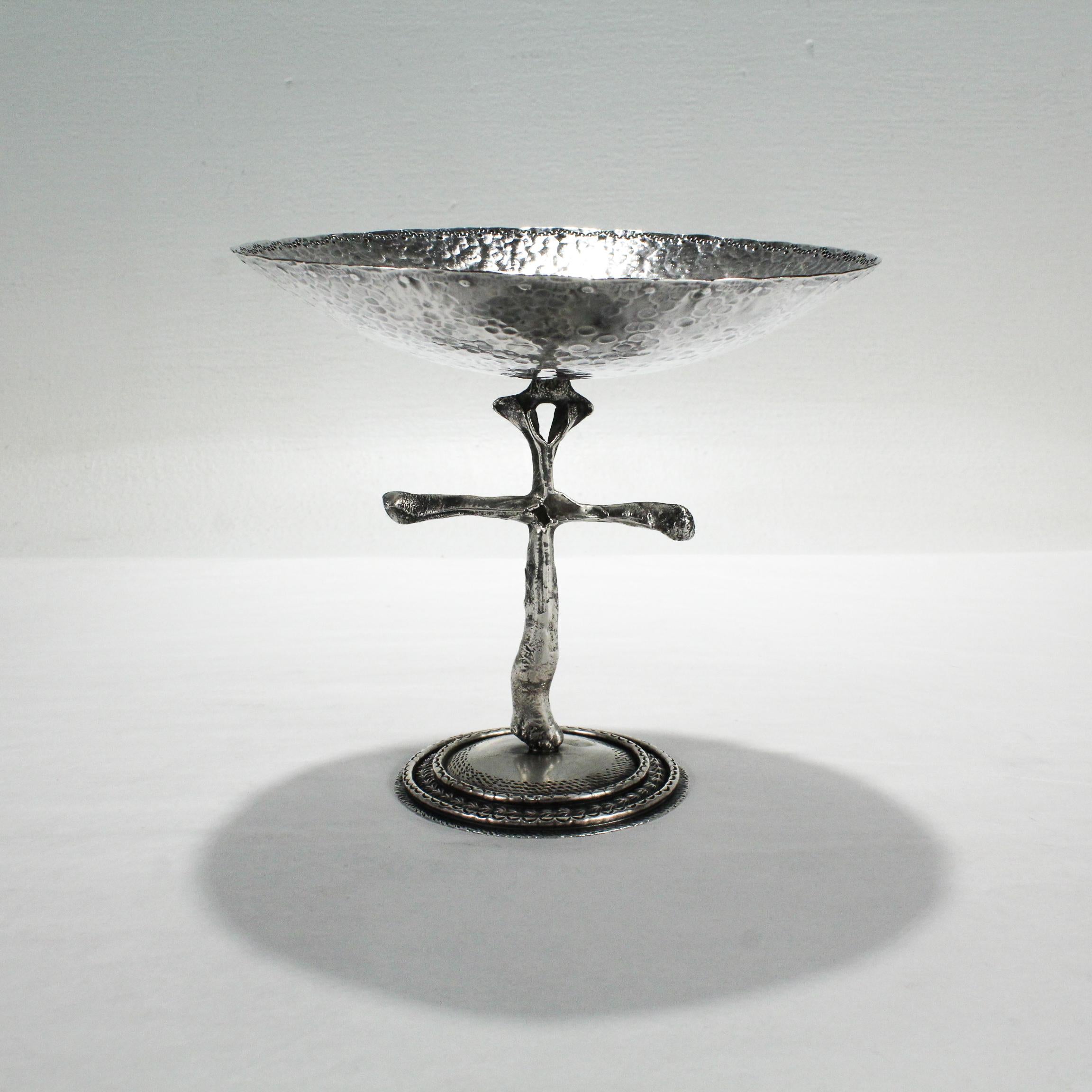 A rare tazza or compote from the renowned Southwestern jewelry artist - Billy Lee Mossman. 

In sterling silver.

With a hand chased foot supporting a cross-shaped pedestal and a hand-hammered bowl.

Simply a wonderful find from an amazing