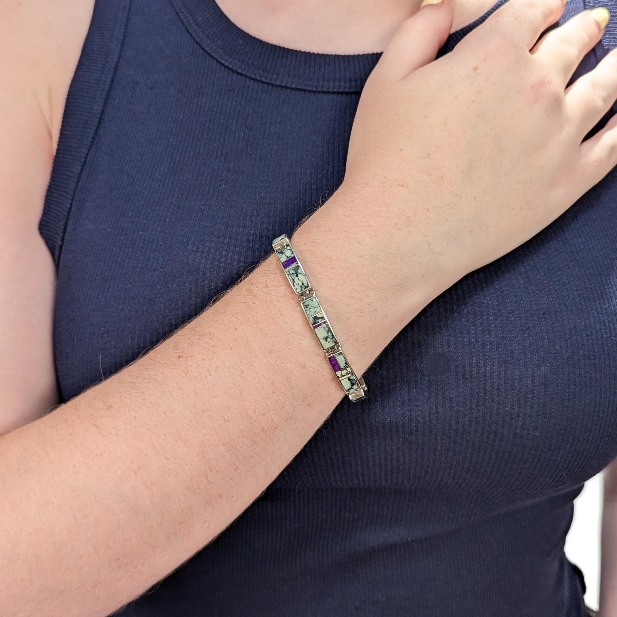 Un fino brazalete firmado por nativos americanos.

Diseñado por Tim Charley para Supersmith.

En plata de ley.

Con incrustaciones de sugilita y (lo que creemos que es) turquesa. La turquesa es posiblemente turquesa 