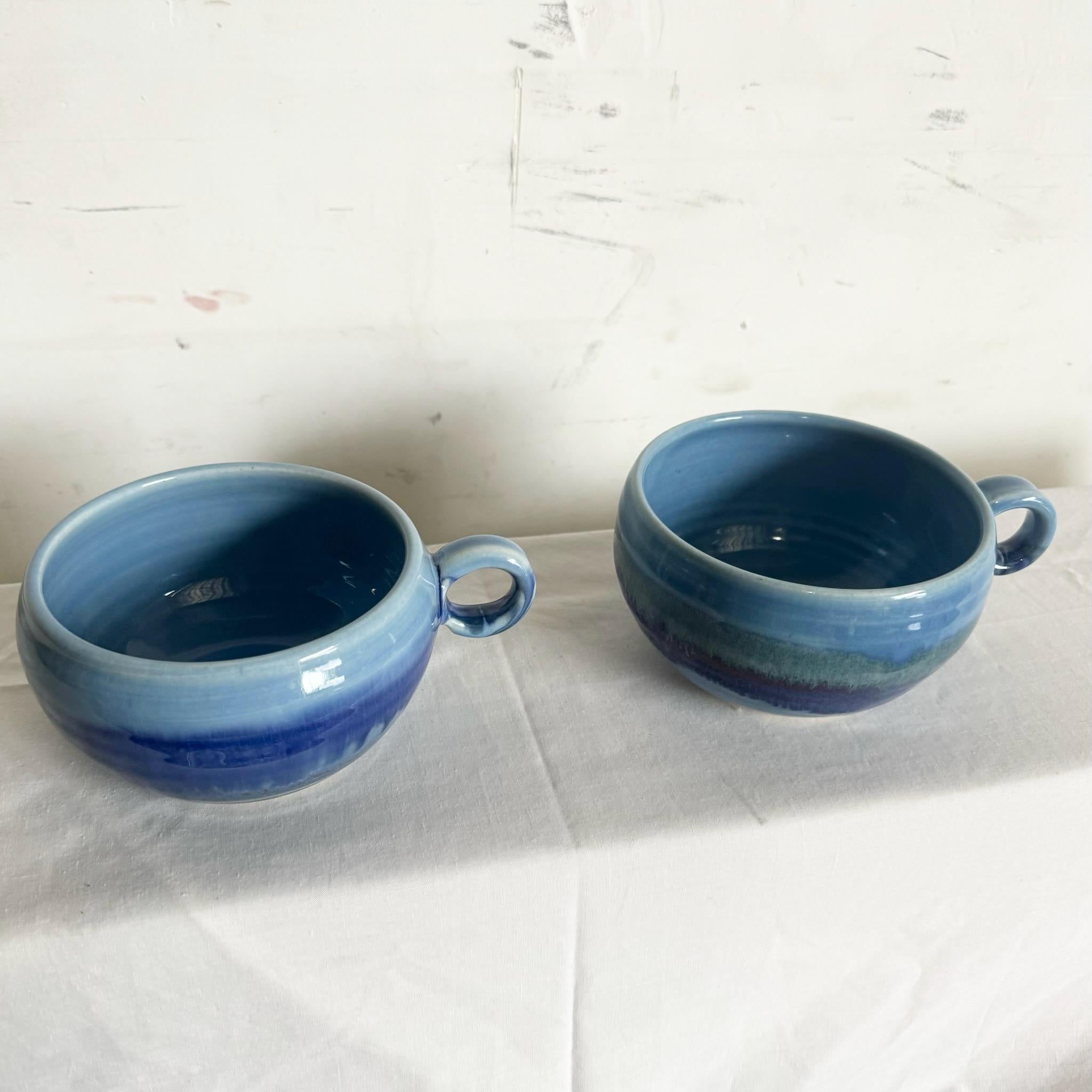 Savourez votre thé ou votre café avec style grâce à cette paire de tasses signées en poterie filée à glaçure bleue. Ces pièces magnifiquement fabriquées à la main présentent une riche glaçure bleue et une finition texturée unique, alliant