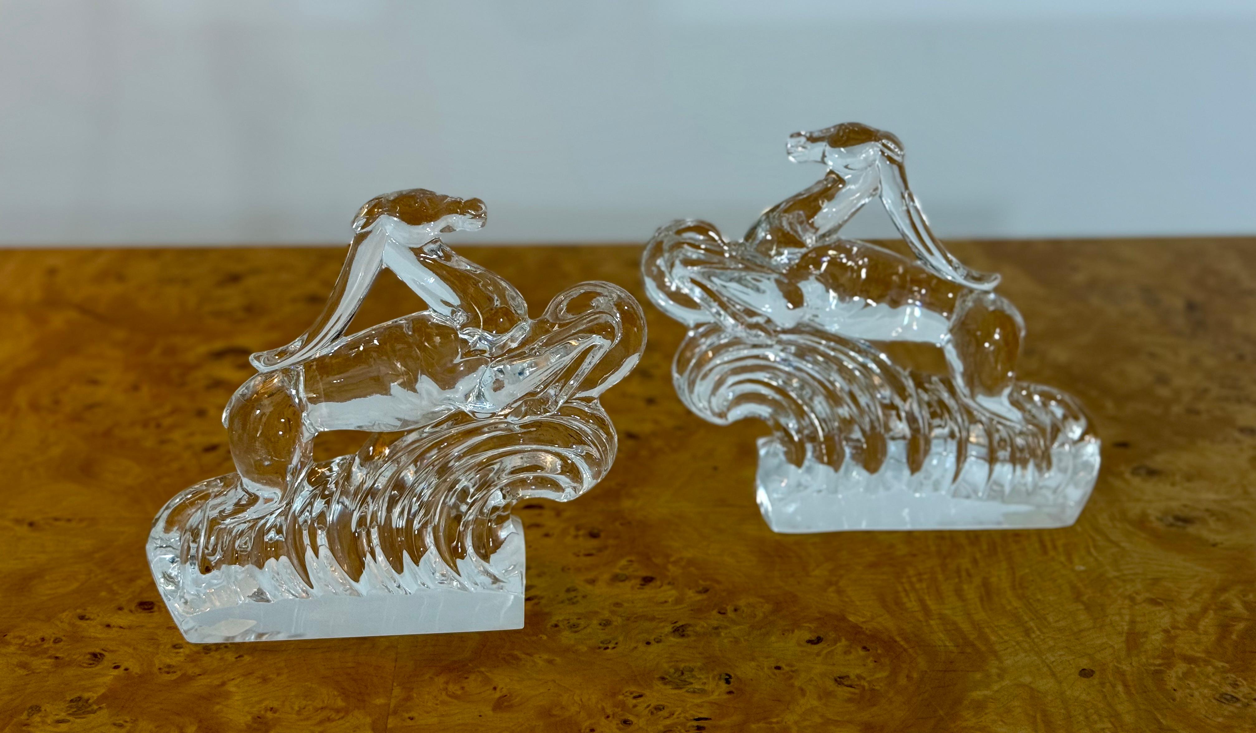 This signed pair of Steuben crystal gazelle bookends showcases the brand’s signature clarity and craftsmanship. Each hand-blown glass figure depicts a stylized gazelle leaping over curling waves—a dynamic composition that evokes the sleek elegance