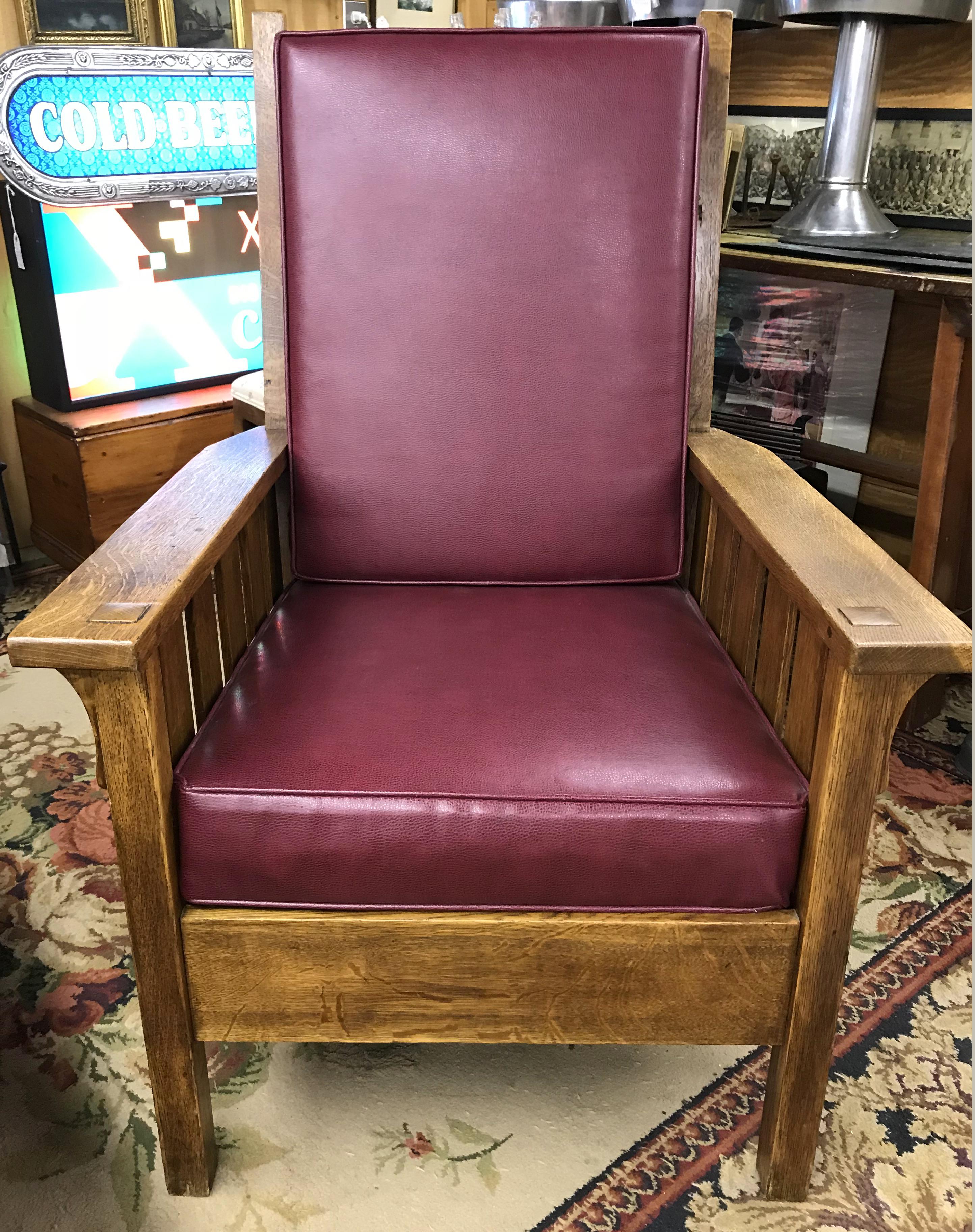 A solid oak Stickley Arts & Crafts Mission armchair with cranberry color leather pad upholstery, with the Stickley Craftsman Workshops brand, dating the piece to circa 1912-1916. Gustav Stickley shifted to a heat brand to mark his furniture during