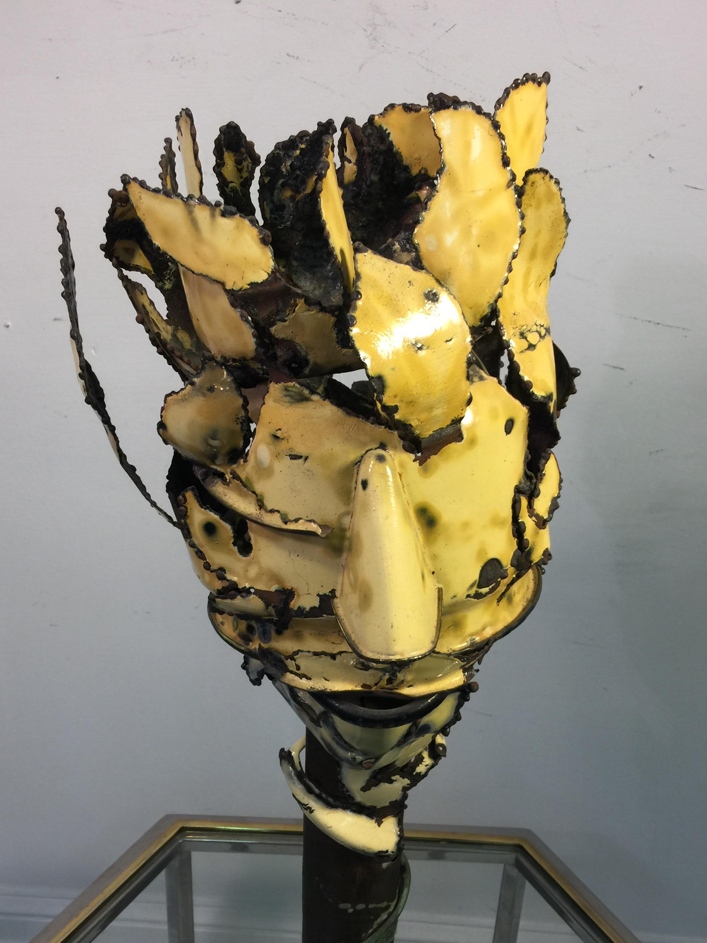 Surrealist flower head sculpture formed with the petals creating a three dimensional head. Hand-sculpted of copper with yellow enamel and vedrigris patination. Signed Pantala and dated 1994.The round base measures at 7 1/2