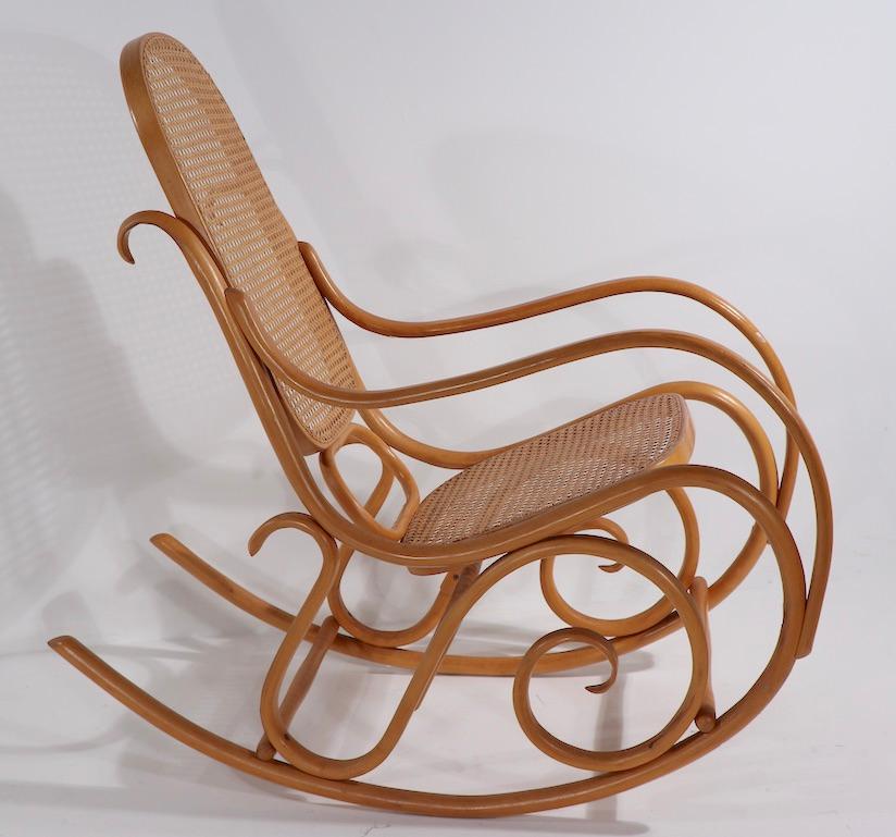 Iconic Schaukelstuhl rocking chair in blonde finish beech with original canned back and seat. This fine example is signed THONET and marked A5, as shown. Probably circa 1970's or 1980's. 
 Measures: Total H 43 x Arm H 23.5 x Seat H 17 x D 42 x W 19