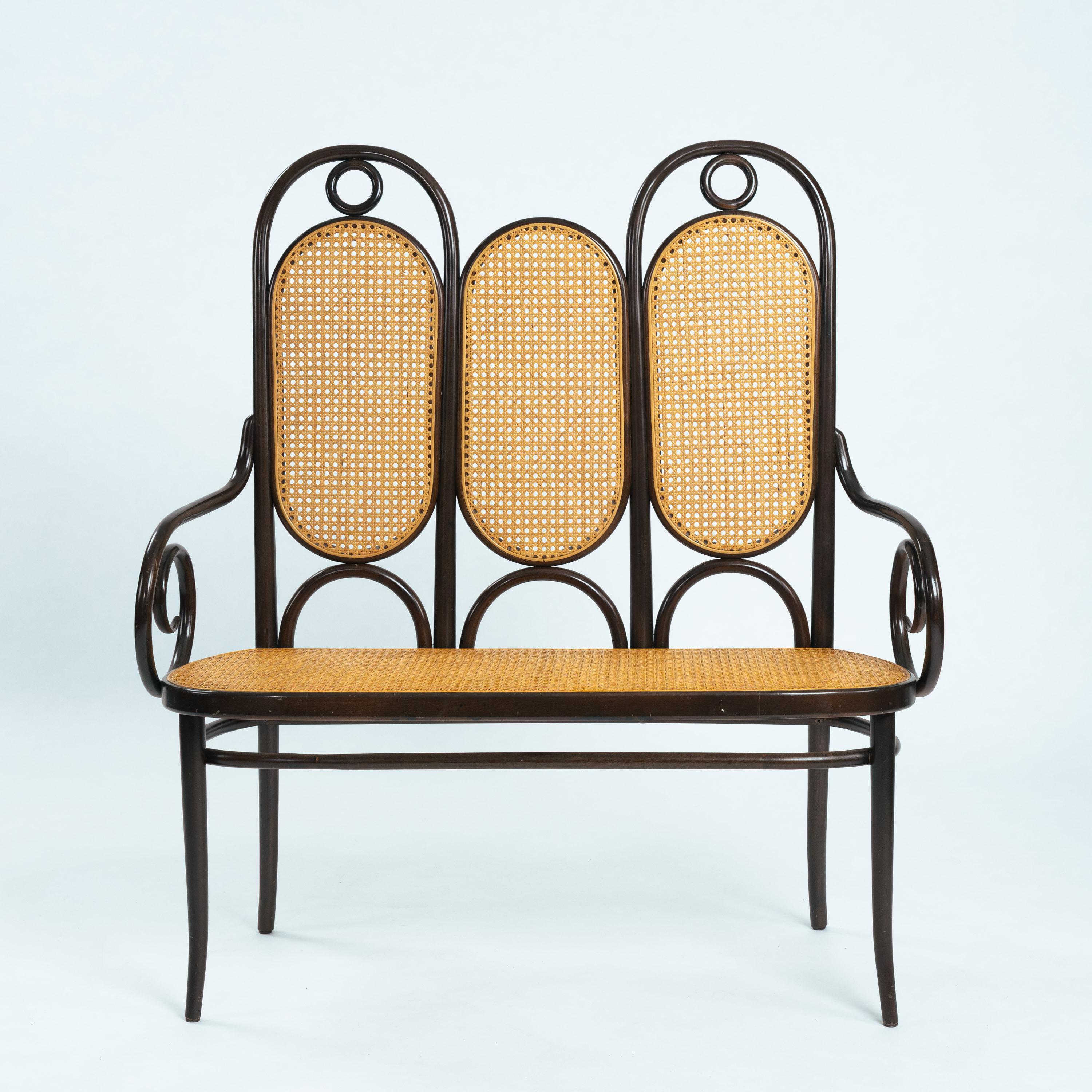 This elegant Thonet bench,  model 207,  also known as Long John, was made by Thonet in 1979. The original design dates from the early 20th century but had a revival in the 1970s.
This bench has dark brown bentwood frame with a newly caned seat. The