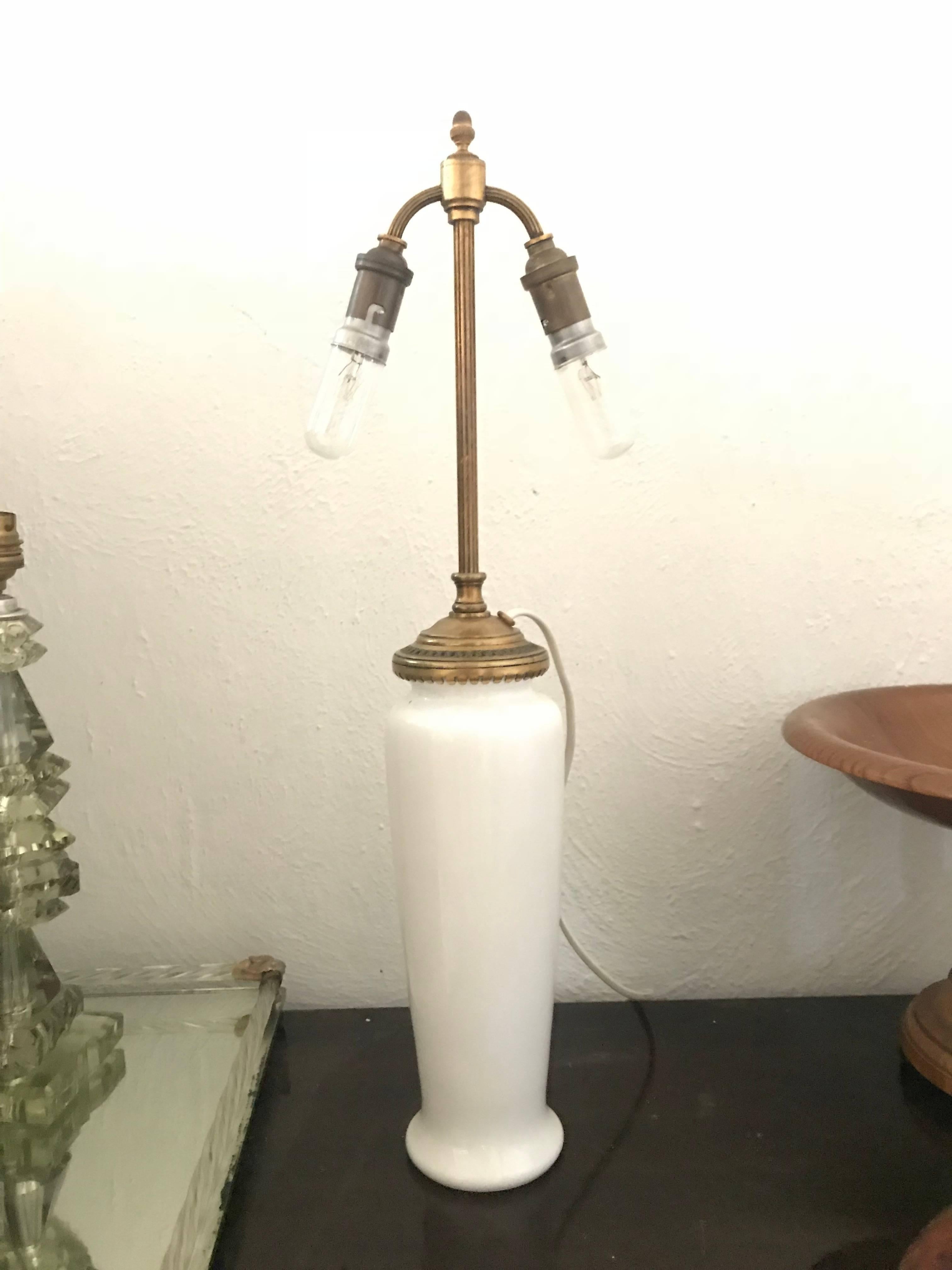 Belle lampe de table de Baccarat, fabriquée en France dans le premier quart du 11e siècle.
La lampe se compose d'un vase en verre opalin blanc et d'une ferrure en bronze à trois lumières qui se visse dans le vase et l'éclaire lorsqu'elle est