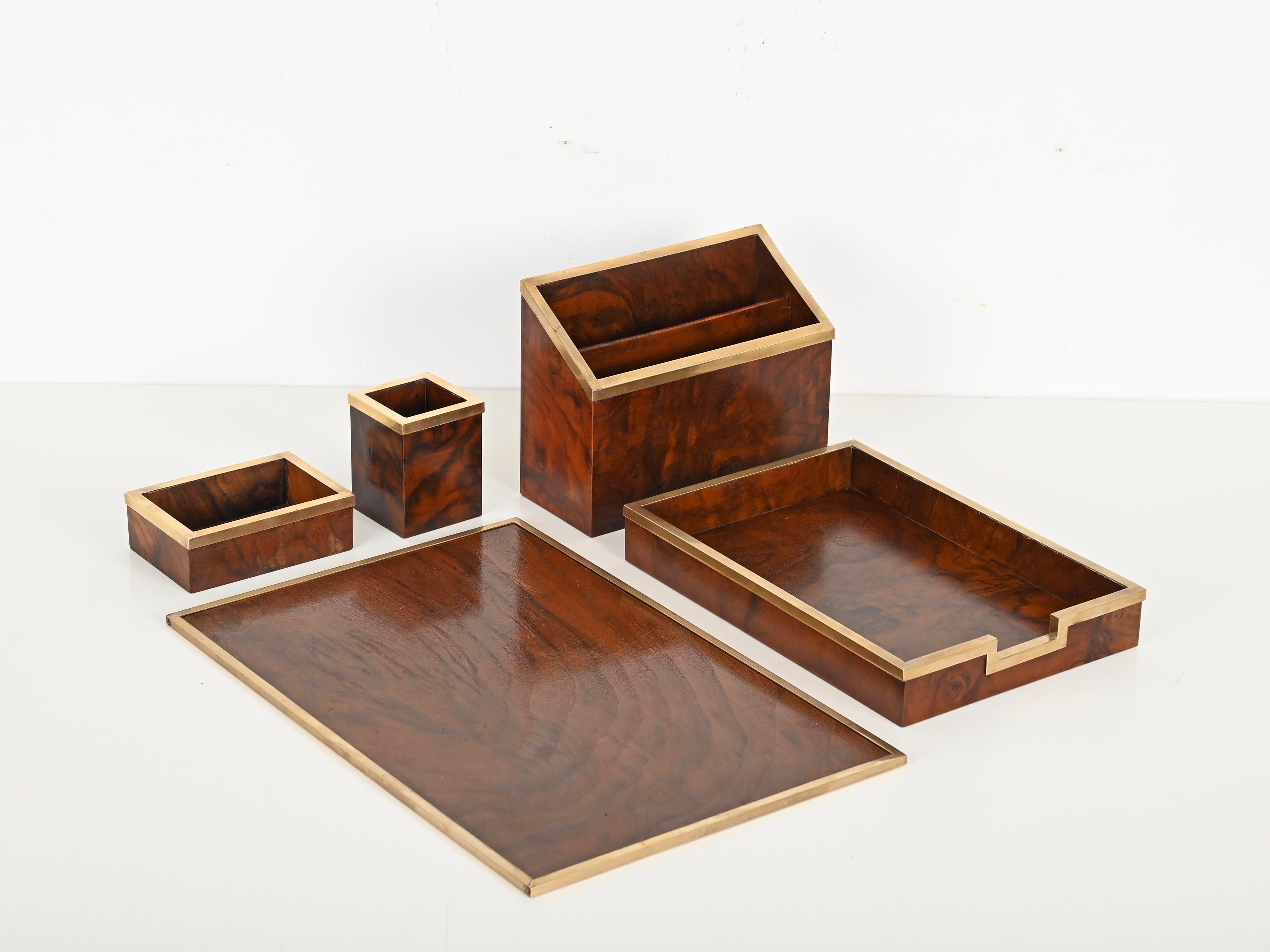 Rare and Elegant desk set in a wonderful walnut burl and brass designed and signed by Tommaso Barbi and produced in Italy during the 1970s.

This exquisite 5-piece desk set features a writing desk pad, a pen holder, a small storage box, a