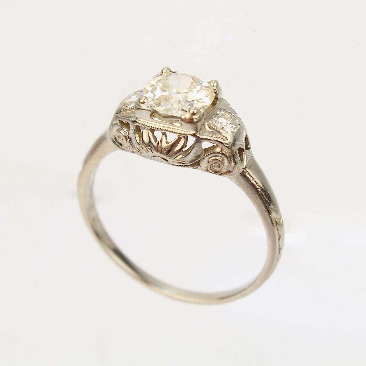 A very fine antique Art Deco Orange Blossom diamond ring.

In 18k white gold with a fine decorative filigree bridge.

Orange Blossom rings are highly desirable and coveted by collectors!

Made by the Traub Manufacturing Co.

The lovely central
