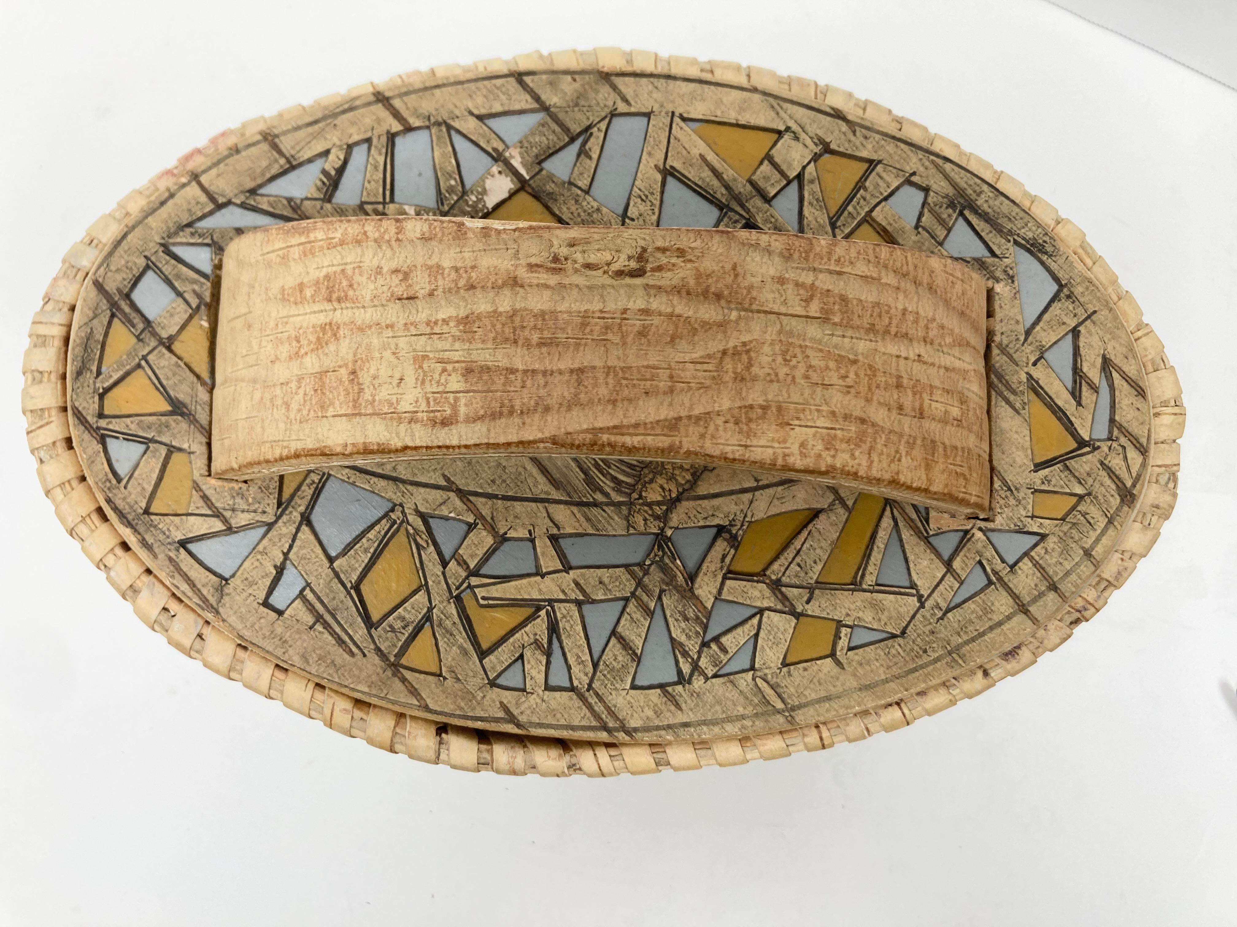 A very well crafted Oval Birch Box with an interesting and stylish pierced and colored surface treatment, thick bent wood handle and woven top edge. At one end, the bent panel has three thick joins which add interest, and a fine and well placed knot