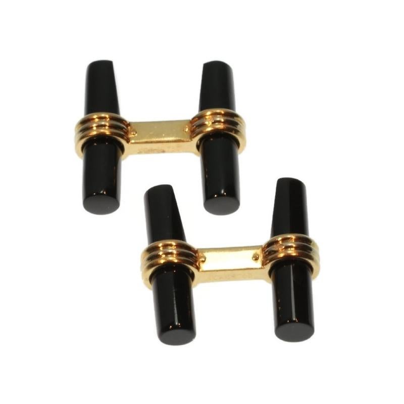 On each side of these Van Cleef & Arpels cufflinks from 1980, there are two 18K yellow gold rings with a white gold one in the middle holding a cylinder cut onyx half tapered on one side. These two French designs complete every gentleman's sleek