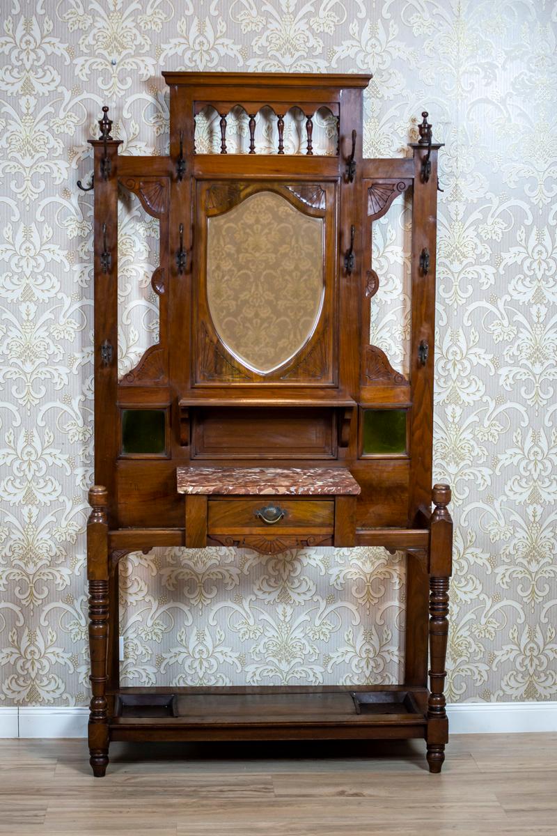 We present you a walnut piece of furniture, circa 1900, with a signature of Bick. Wright & Co.
This closet is in the form of an openwork wall with mirror, which is topped with a gallery.
There are evenly spaced brass coat-hooks, finished with