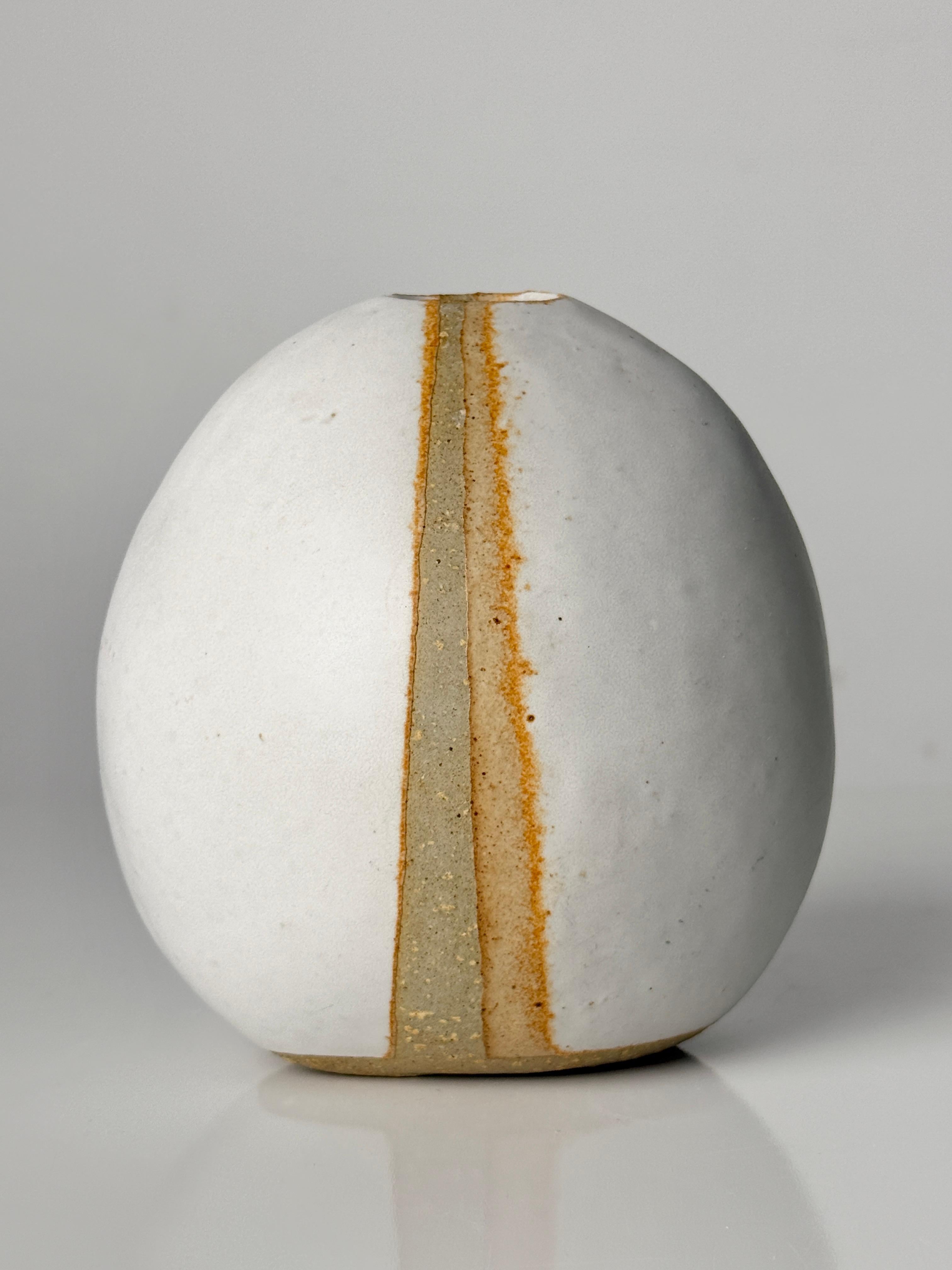 Vase moderniste de l'artiste céramiste américain Warren Hullow de Hickory Grove Studio circa 1970

Forme ovoïde peu profonde en glaçure blanche mate avec détail de réserve verticale au centre.
Signature incisée sur la face inférieure

Largeur de 4.5