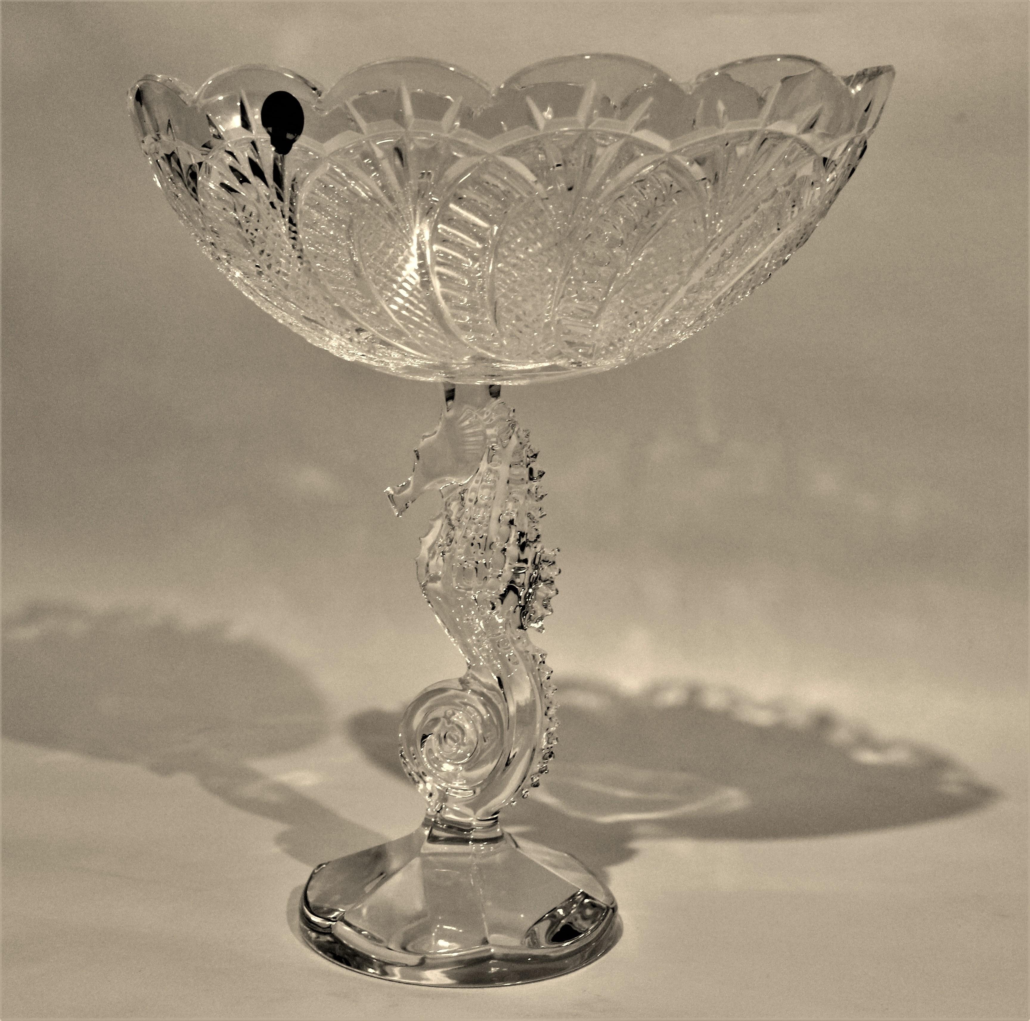 Substantial signed Waterford cut crystal footed centerpiece bowl accented by a figural seahorse in the stem portion of the base. The bowl has scalloped edges around the rim and deep facets that accent the interior. The piece is signed with the foil