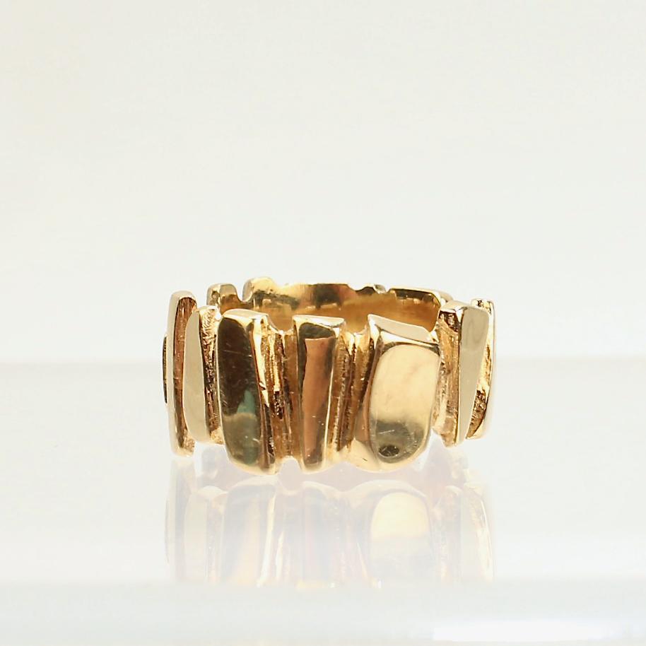 An impressive, signed Wesley Emmons ring.

Comprised of 14k yellow gold, this thick gauge ring has a staggered, polished arrow head design around its circumference.

Emmons was an important jewelry maker in Philadelphia during the mid-20th century.