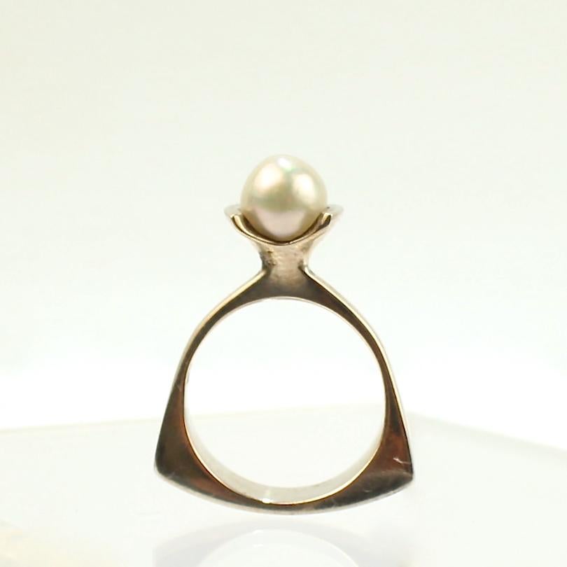 An impressive, signed Wesley Emmons ring.

Comprised of sterling silver, this fine rocker based ring is set with a roundish white pearl.

Emmons was an important jewelry maker in Philadelphia during the mid-20th century. He created cutting-edge