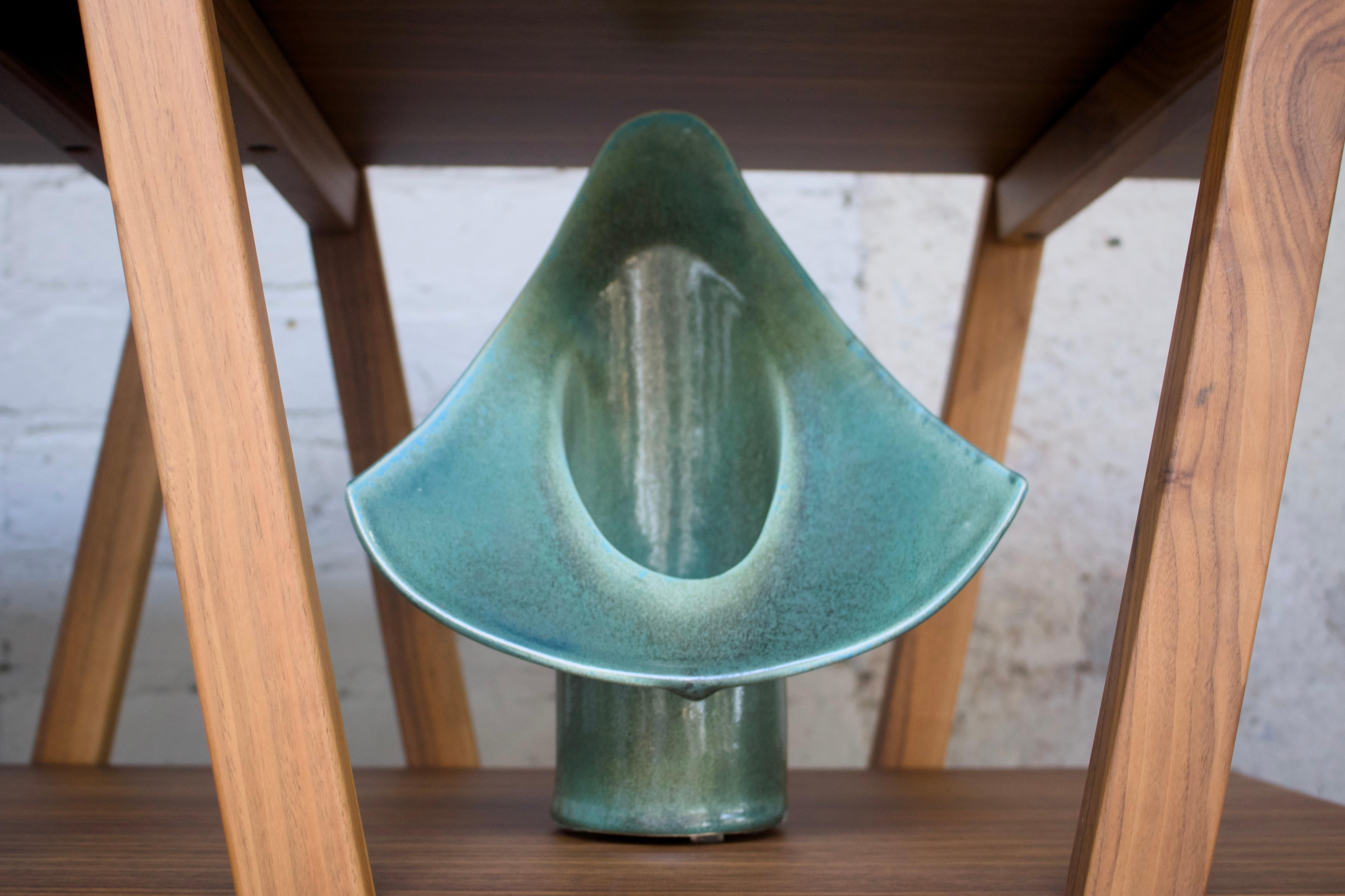 This dramatic signed vintage Mid Century Modern vessel features triangular wings, iconic of the Brutalist style. The Brutalist wings flare out around the vintage vessel and taper up to a rounded point. Hand-thrown and coated in glossy glaze with