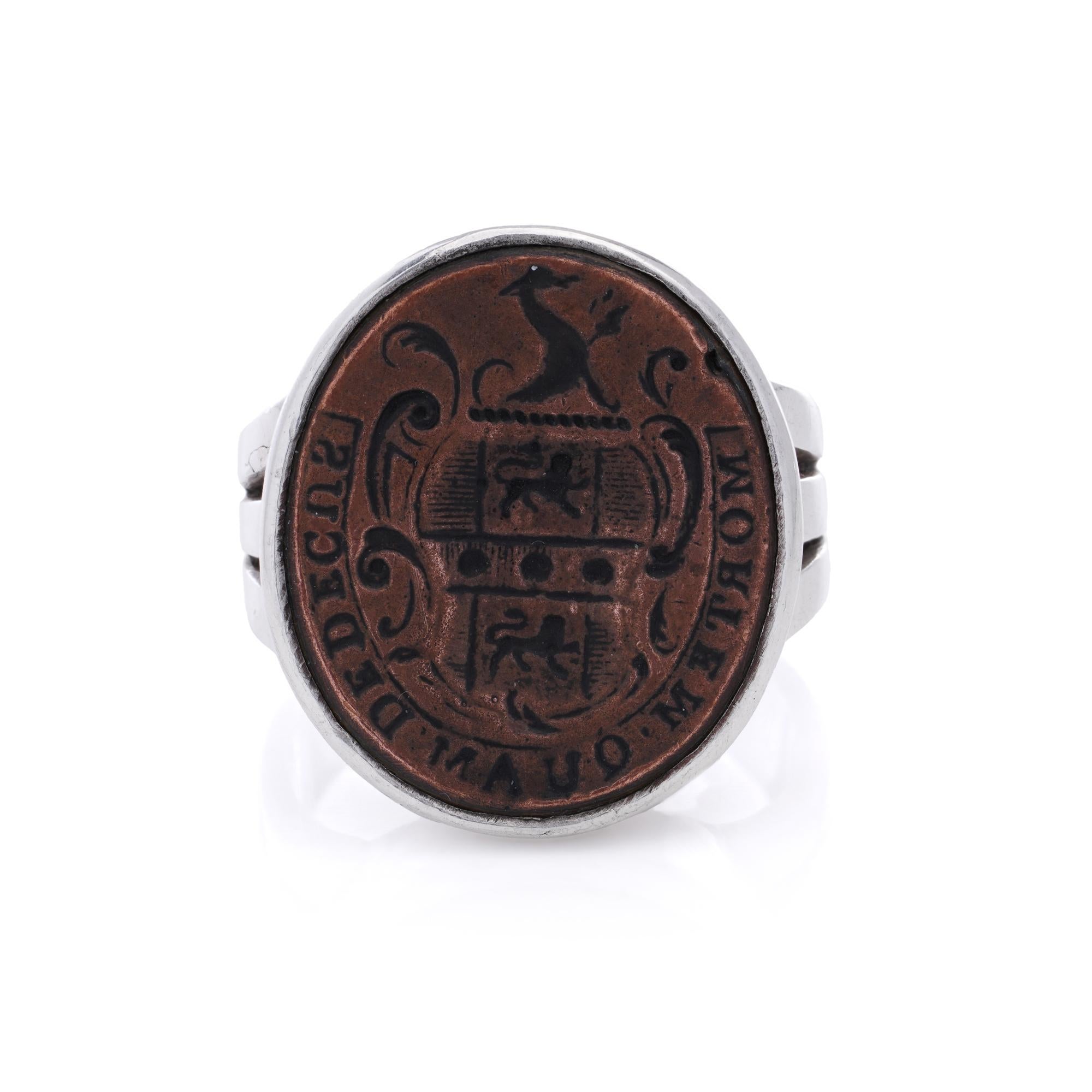 This striking signet ring is crafted with a silver band and a copper crest, showcasing exceptional detail and historical significance. The centerpiece of the ring features a heraldic crest, with intricate design elements such as a shield and