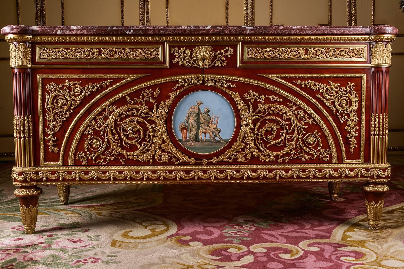Veneered roots on solid oak and pine. Exceptionally fine engraved and richly moulded bronze Appliqués. Right Angled Body. In the bowed front can be
found two wide doors with recessed contents, flanked by conical, grooved legs, ending in sabots. The