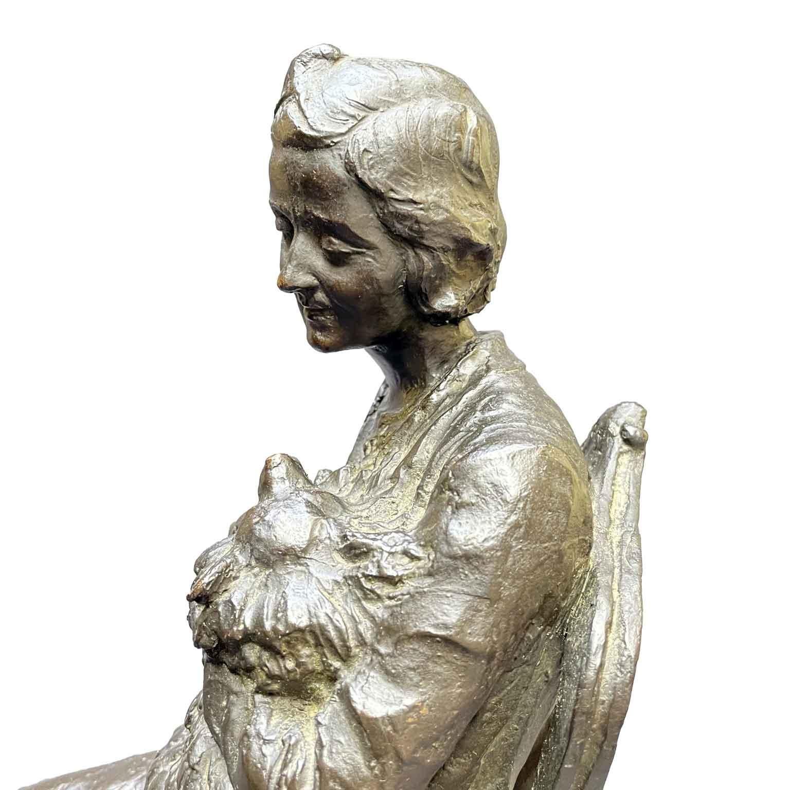 Leonardo Secchi Lady Sitting With Dog 1942 dark patina earthenware casting depicts a woman sitting on a chair over an oriental rug as she lovingly embraces and cuddles her dog. The casting sits atop a black veined marble base with minimal chipping.