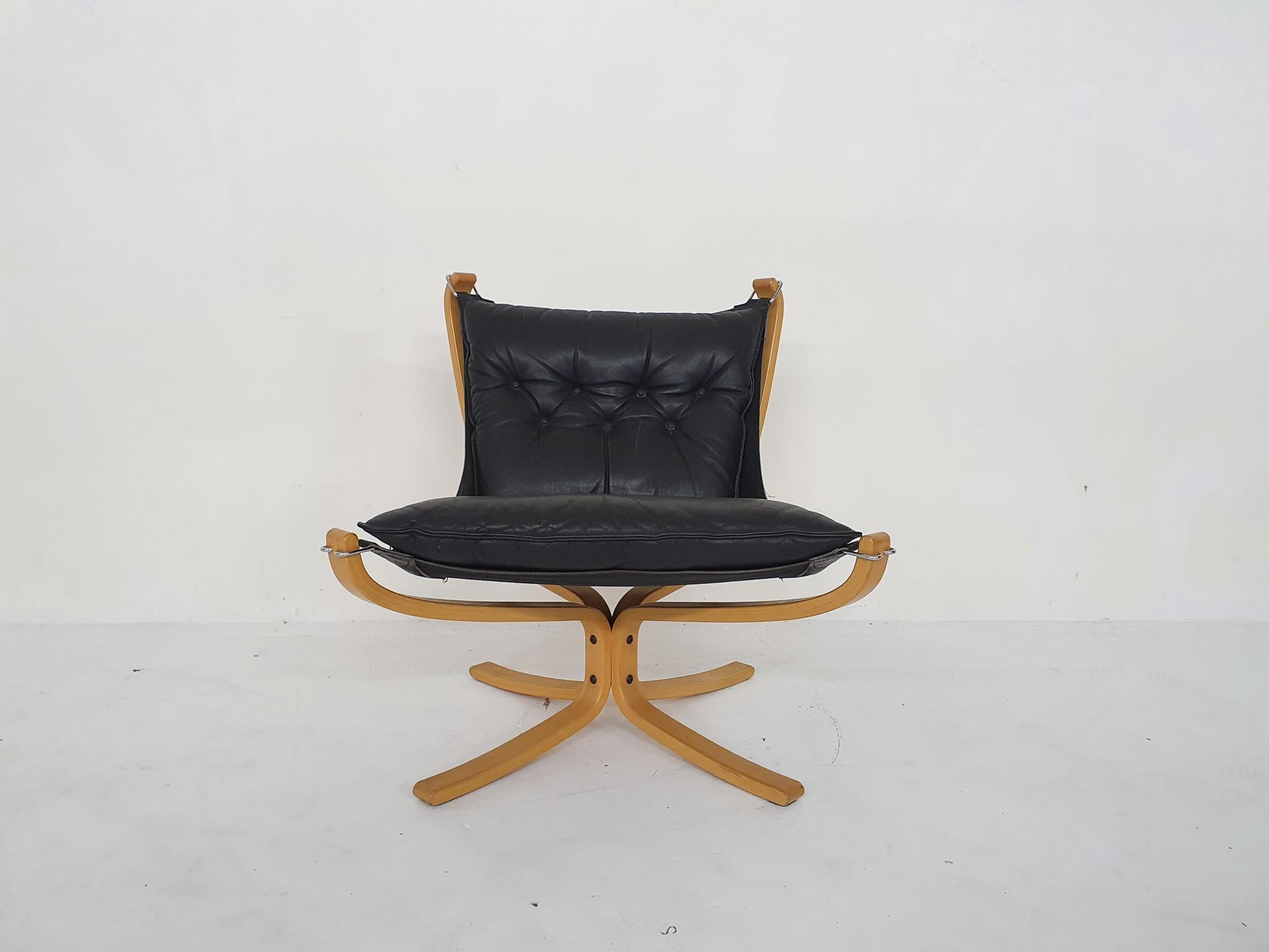 Wooden lounge chair with canvas back and black leather cushhion. One button has been replaced by a larger one.
In good condition.