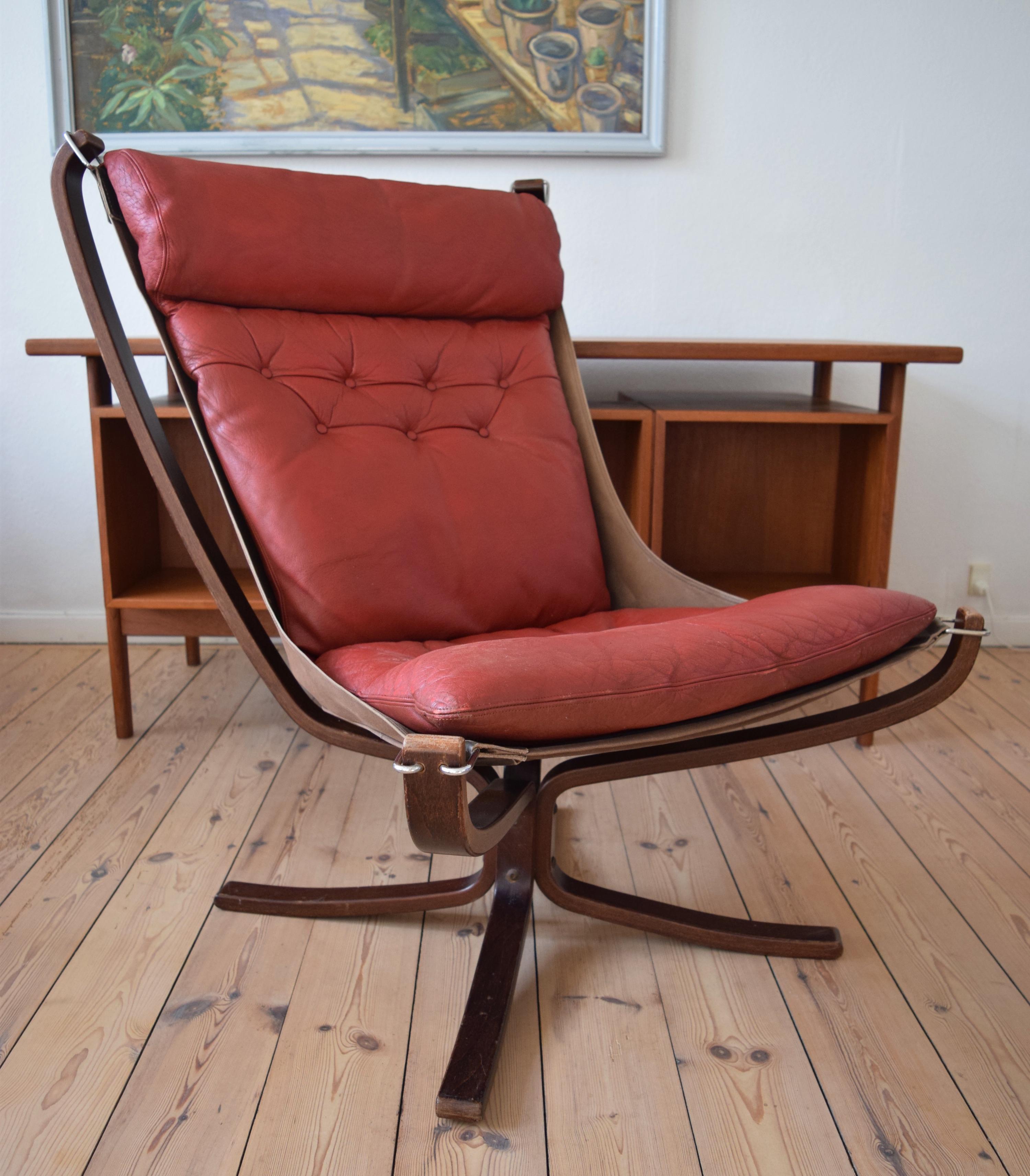 Falcon chair designed by Sigurd Ressel and manufactured by Vatne Møbler in Norway in the 1970s. Features red leather cushion and sits on a canvas hammock. The leather is in great shape and is still soft and supple. All the hooks and canvas on the