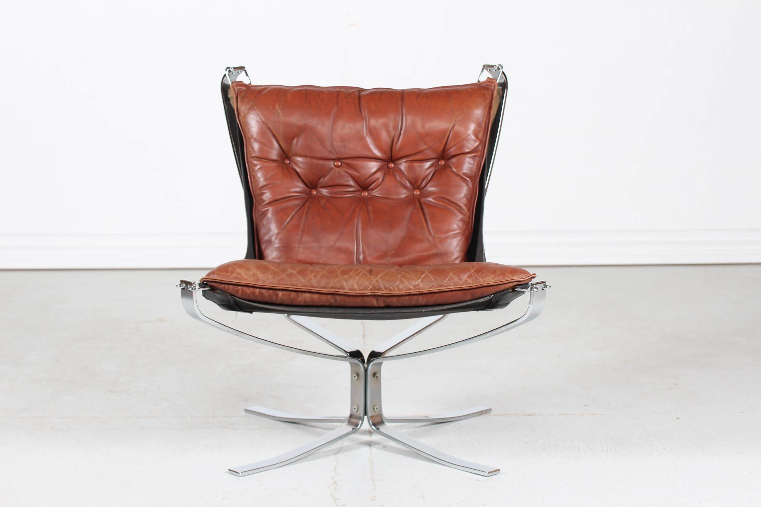 A Falcon easy chair/ lounge chair designed by Sigurd Ressell. Manufactured by Vatne Møbler Norway in 1970s
The chair has a chromium-plated steel frame stretched with black fabric. The cushion is upholstered with genuine dark cognac colored