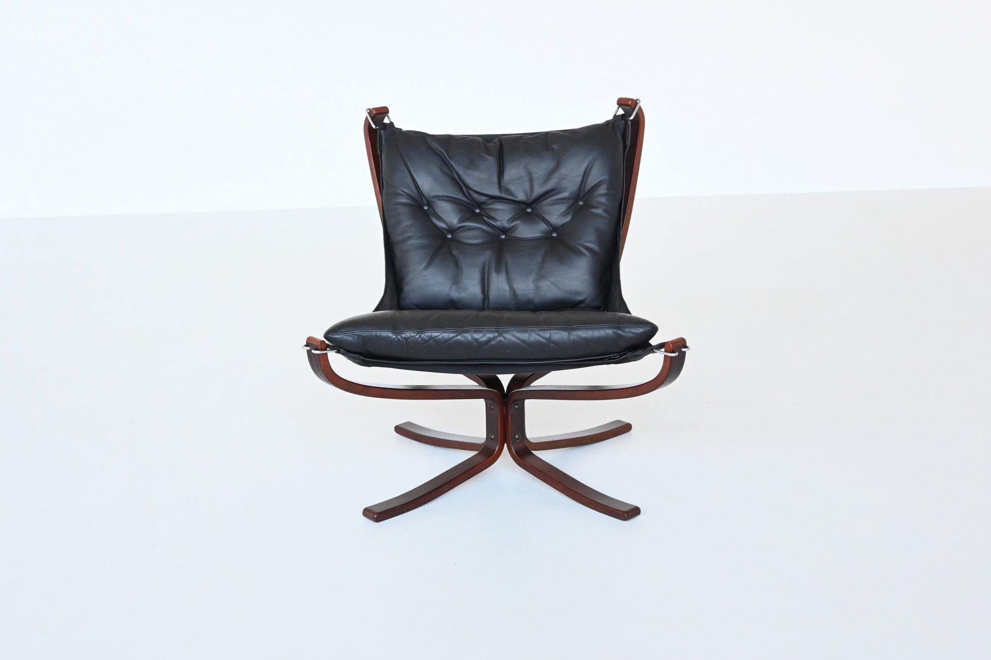 Iconic X-framed low back Falcon lounge chair designed by Sigurd Ressell for Vatne Mobler, Norway 1970. It is a notable example of Scandinavian mid-century design. This chair combines a suspended black leather seat with a distinctive frame of stained