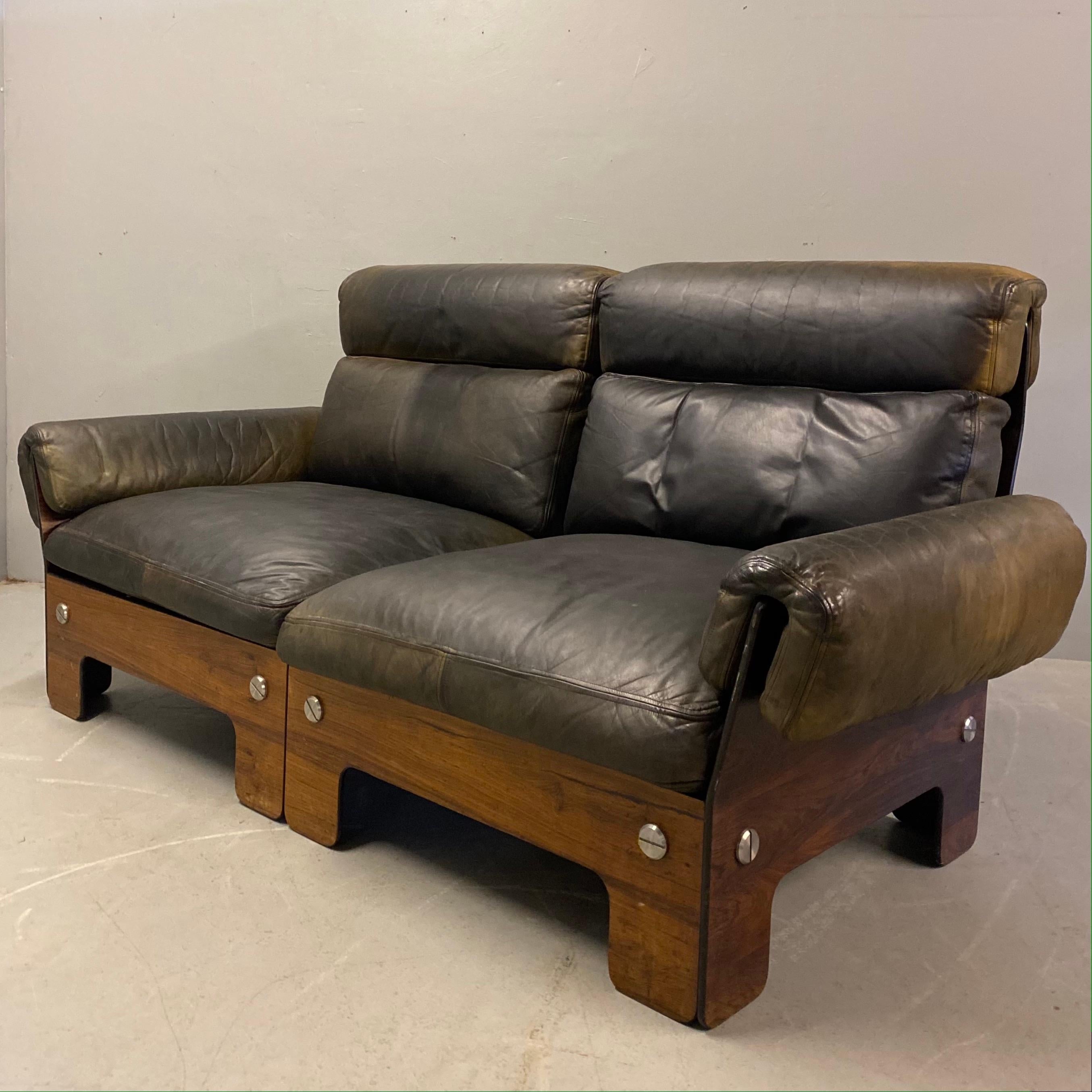 A stunning midcentury Norwegian rosewood & leather two seater sofa designed by Siguard Ressell for Vatne Mobley. This beautiful leather sofa has chrome fixings & pirelli rubber seat supports. The leather arms are attached by large press studs. The