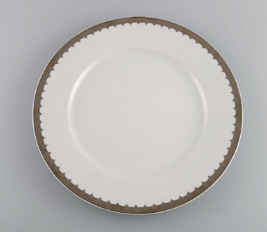 Sigvard Bernadotte for Christineholm. 
Twelve large dinner plates in porcelain with silver border. 1980s.
Diameter: 30.5 cm.
In excellent condition.
Stamped.