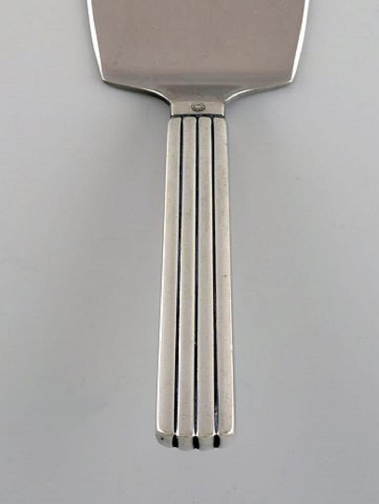 Sigvard Bernadotte for Georg Jensen. Bernadotte serving spade in sterling silver and stainless steel.
Measure: Length: 16.2 cm.
Stamped.
In excellent condition.
Our skilled Georg Jensen silversmith / goldsmith can polish all silver and gold so