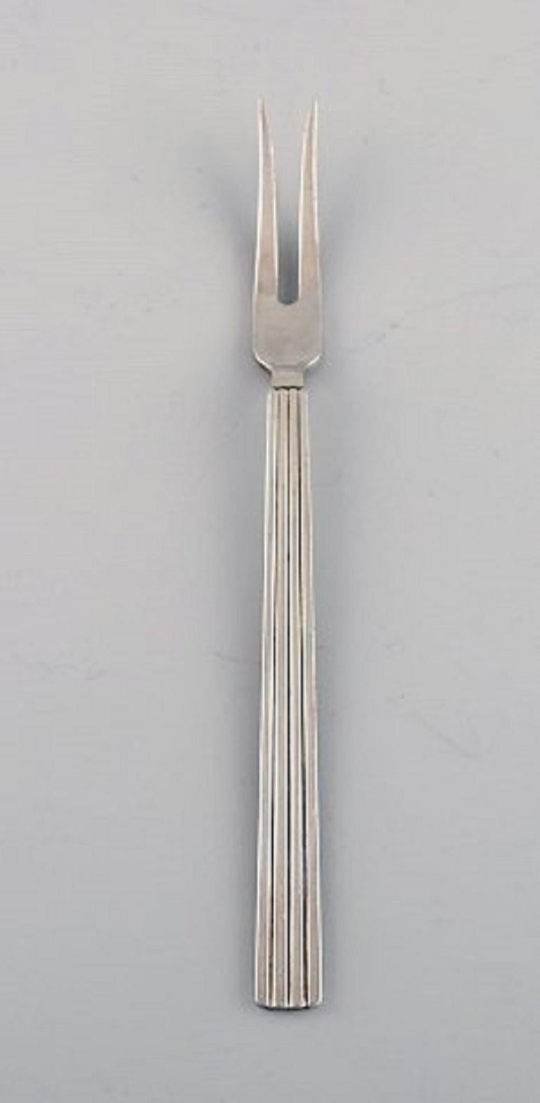 Sigvard Bernadotte for Georg Jensen. Two Bernadotte cold meat forks in sterling silver.
Length: 15 cm.
Stamped.
In excellent condition.
Our skilled Georg Jensen silversmith / goldsmith can polish all silver and gold so that it looks like new.