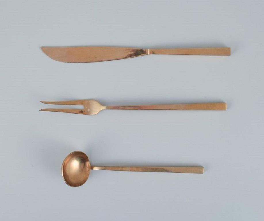 Sigvard Bernadotte 'Scanline' brass cutlery.
Complete dinner service for 12 people.
Consisting of 12 dinner knives, 12 dinner forks, 12 tablespoons, 12 teaspoons, 12 cake forks and various serving parts. 
63 parts in total.
Danish design