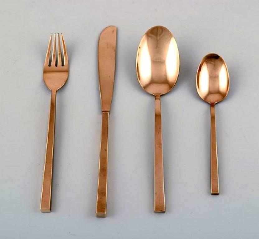 Sigvard Bernadotte 'Scanline' cutlery of brass complete for twelve p. Consisting of: 12 dinner knives, 12 dinner forks, 12 soup spoons, 12 dessert spoons, various serving pieces. 
A total of 53 parts.
In very good condition. 
Danish design,