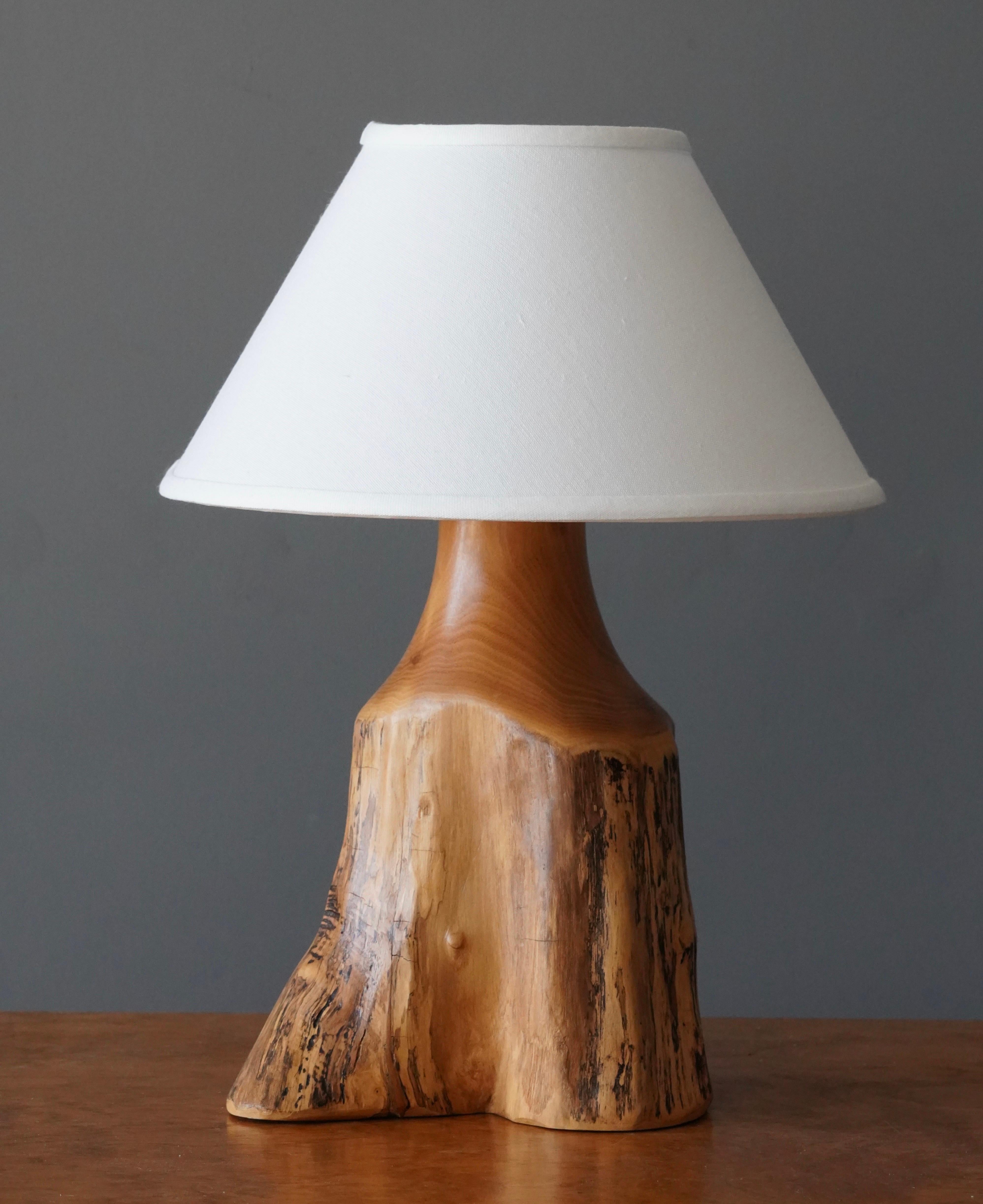 A table lamp. Designed and produced by Sigvard Nilsson for his own studio, Söwe Konst, Sweden, c. 1970s. Signed.

In solid cottonwood.

Dimensions listed are without shade. 
Dimensions with shade: Height is 16.5 inches, Width is 12.25