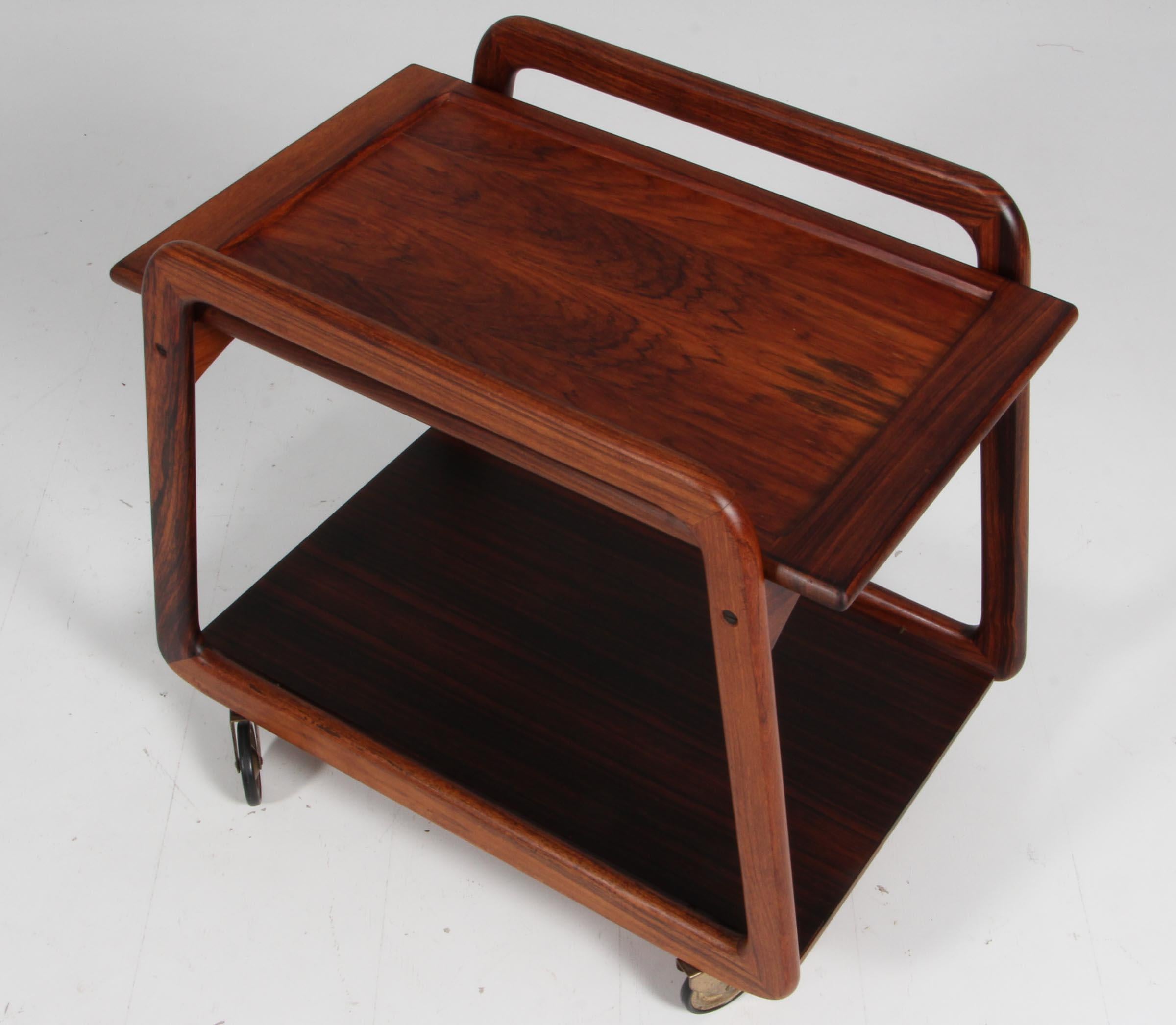Sika Møbler bar cart in rosewood with trays. Upper tray with formica on other side.

With wheels of brass.