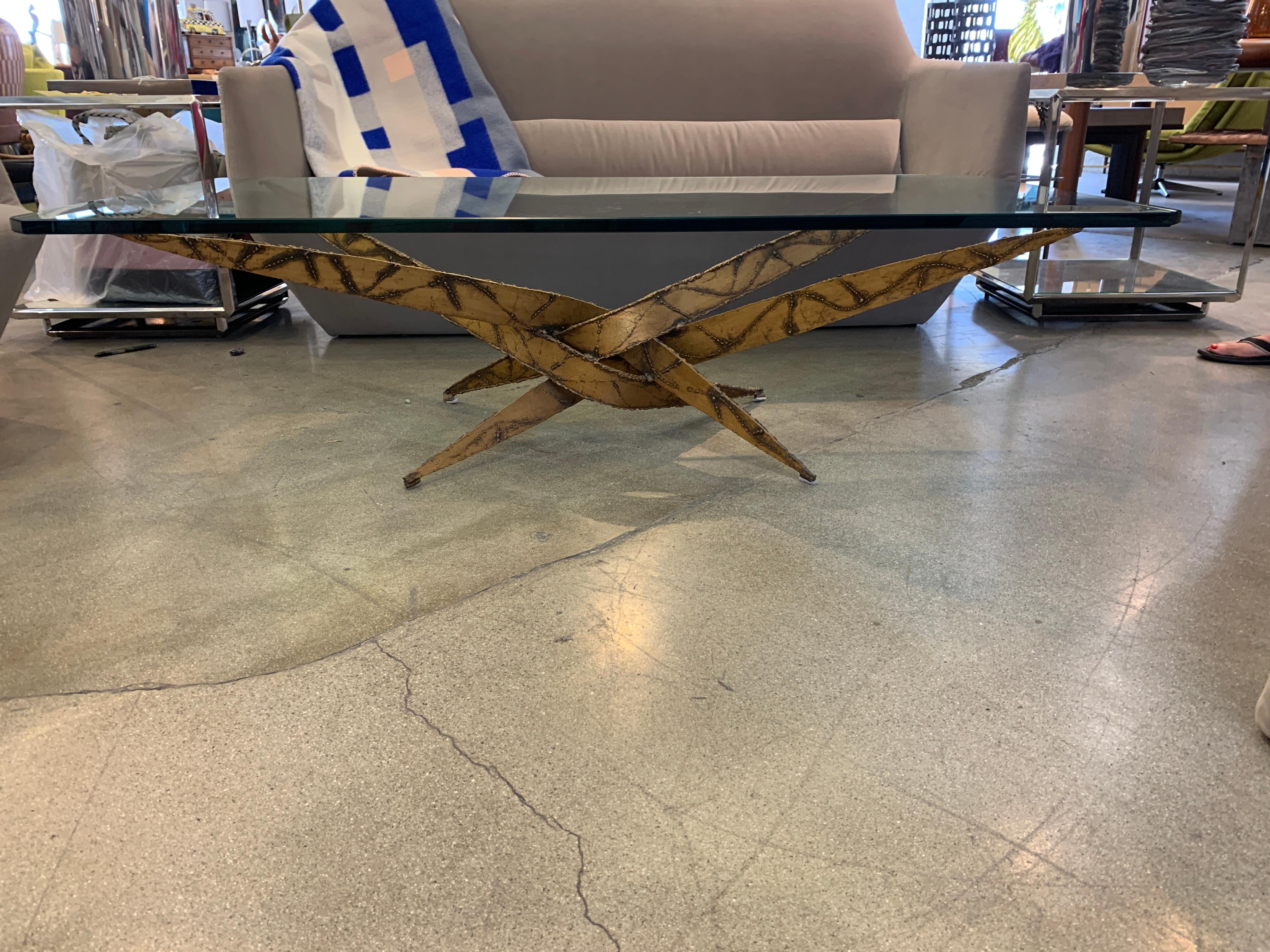A Brutalist iron coffee table designed by Silas Seandel. This table has also been attributed to Daniel Gluck. It is torch cut Iron. Glass is 3/4 of an inch thick. The glass top measures approx 59.75 inches x 29.75 inches. It is approx 16.25 inches
