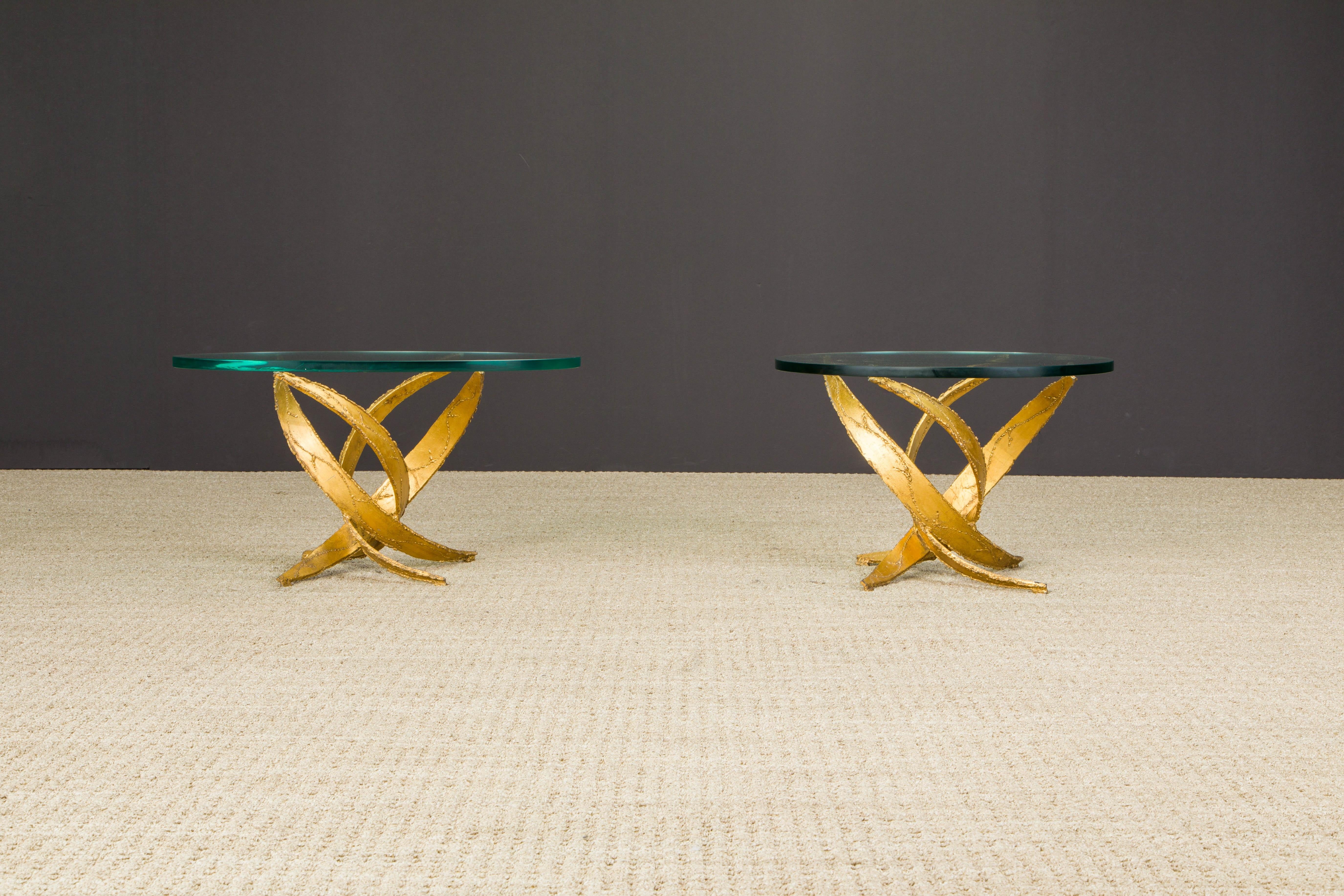 This pair of sculptural Silas Seandel Brutalist side tables are constructed of sections of curved gold tone torch cut metal which have been formed into an organically abstract structure and functional art piece. This structure balances a piece of
