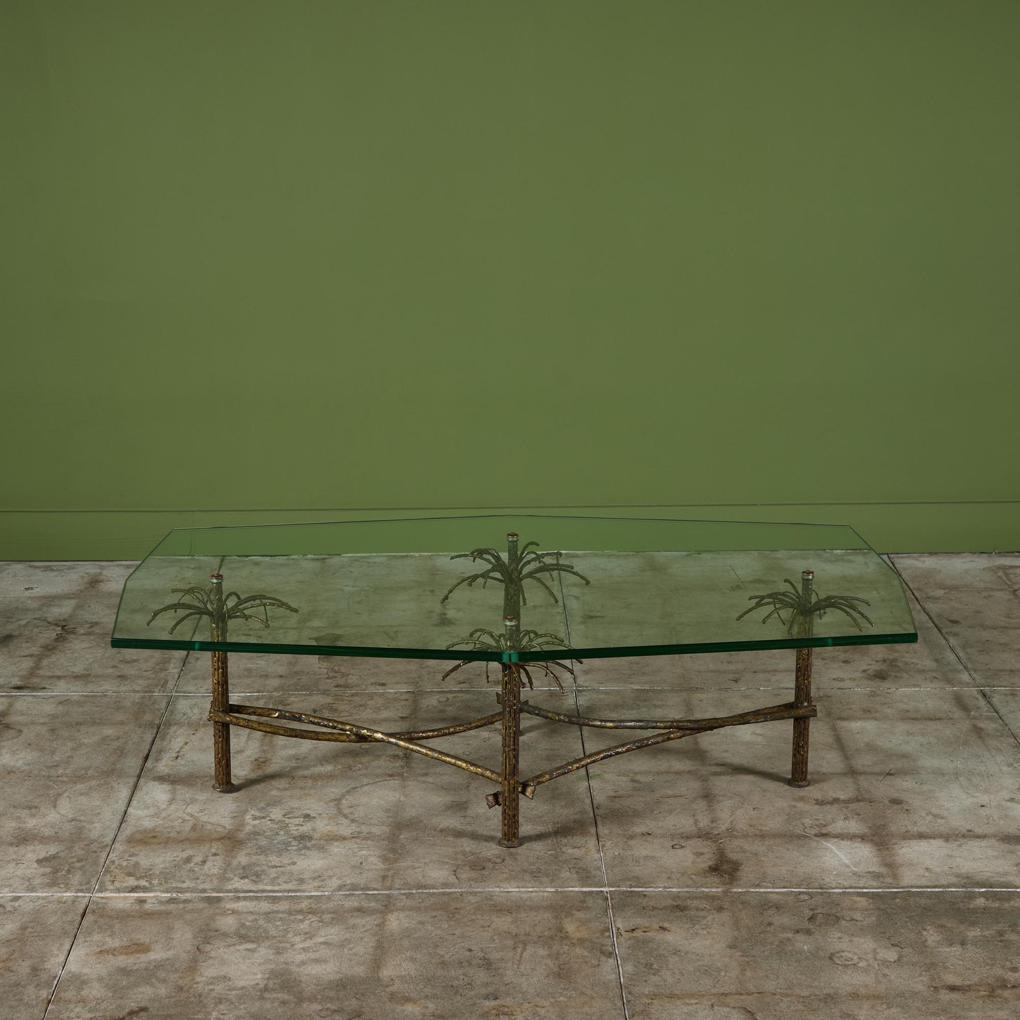 Table basse brutaliste octogonale dans le style de Silas Seandel, c.1960. La table se compose d'un plateau en verre épais posé sur une base en métal doré. Le haut de chaque jambe est orné d'un palmier, juste sous le verre. Les pieds sont reliés