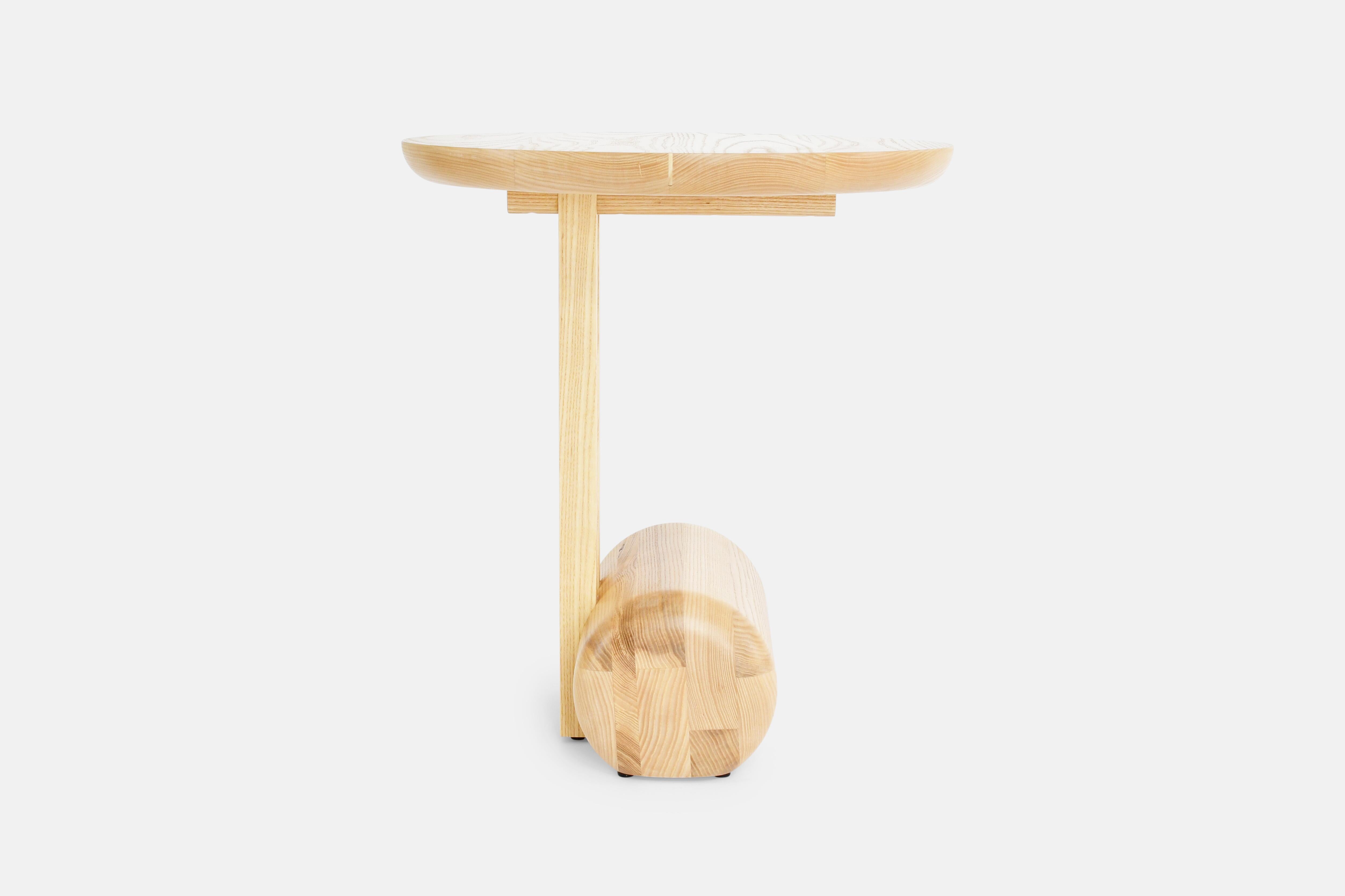 The Silas side table is an exploration of balance and asymmetry with its interpretation in the simplicity of the basic shapes. The round top and rectangular posts are securely anchored to the floor by the solid wood cylindrical base. This pair is