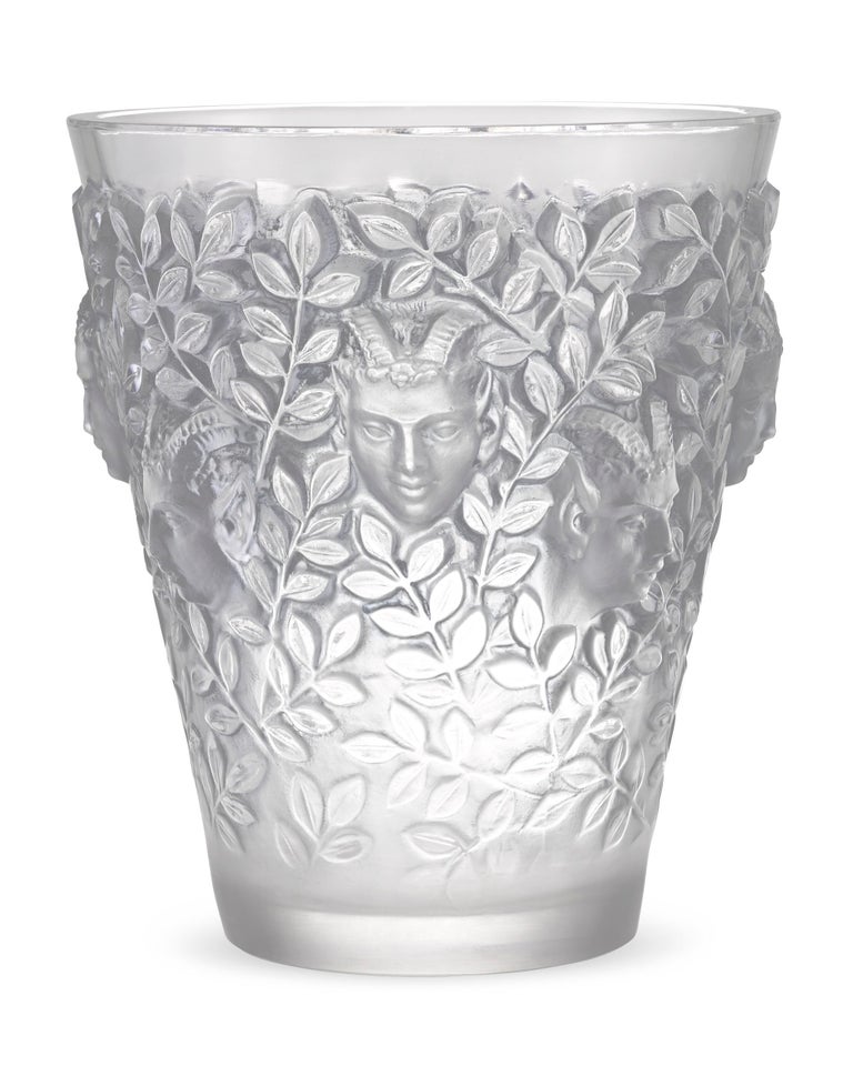 This rare glass vase was created by the famed René Lalique. Crafted of both clear and frosted glass in the expressive Silenes pattern created by Lalique in 1938, this vessel features a repeating design of the Greek god Pan. The god of the wild is