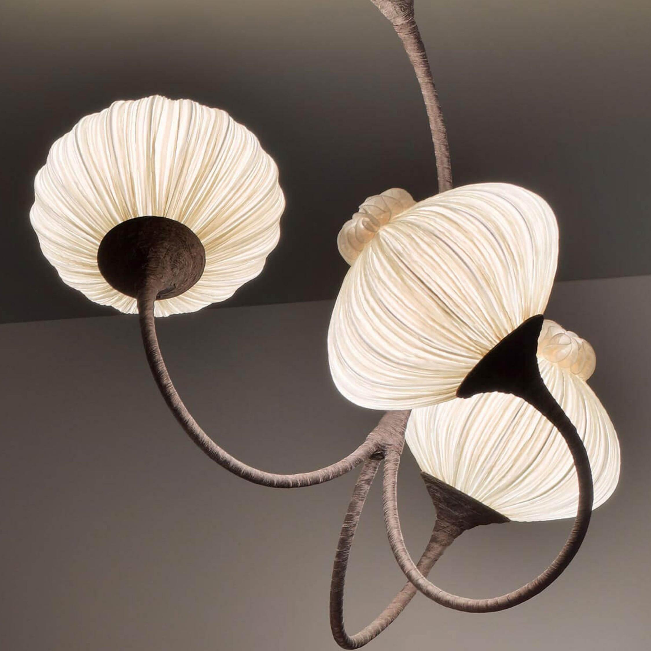 The 3 Palms chandelier is inspired by nature and plays with movement. The highly-stylized curvilinear branches of the ceiling fixture are made from hand-bent metal tubes wrapped in dark bronze organza fabric. All shades are detachable. 3 Palms