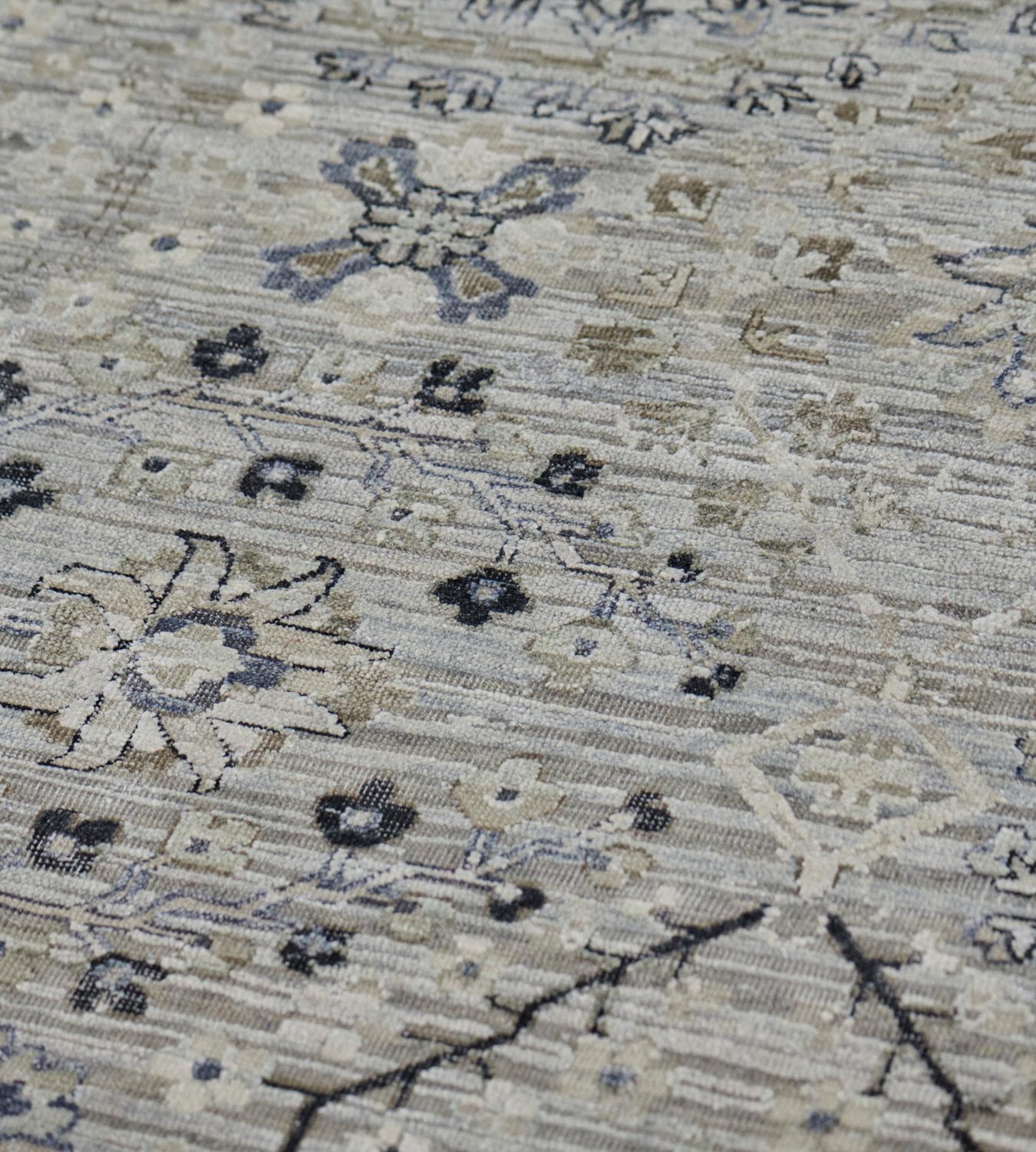 Ce tapis Tabriz de style renaissance, en laine et soie, présente un champ bleu acier avec un motif général de losanges en treillis floral ivoire et noir anthracite, chacun contenant une délicate gerbe florale alternant avec une palmette unique, dans