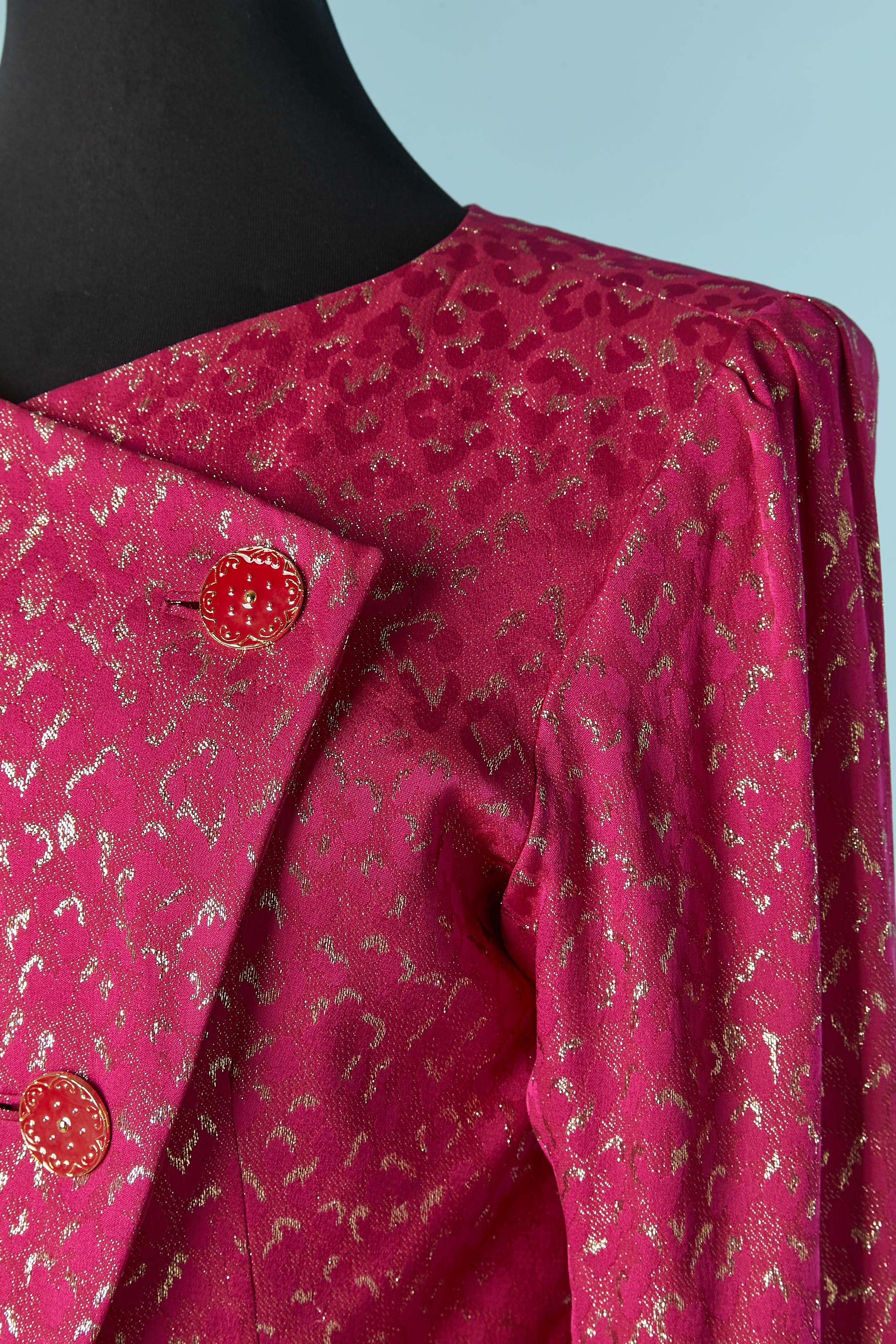 Completo da sera con giacca e gonna in seta jacquard. Composizione del tessuto principale: 86% seta, 14% fili metallici. Fodera: 100% rayon. 
Chiusura con bottoni e asole sul davanti e sui polsini. Spallaccio. 
TAGLIA DELLA GIACCA: 38 (Fr) sulla