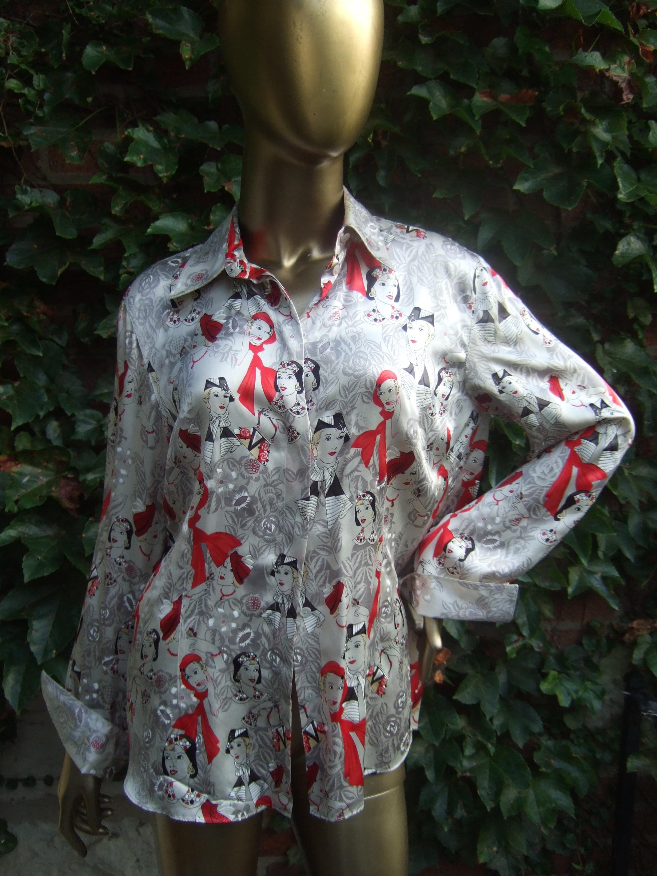 Camicetta da donna in seta charmeuse con stampa grafica ispirata all'Art Déco C.C.
L'elegante camicetta di seta è illustrata con una collezione di eleganti oggetti art déco.
donne dell'era circondate da sottili disegni floreali

Adornato da una
