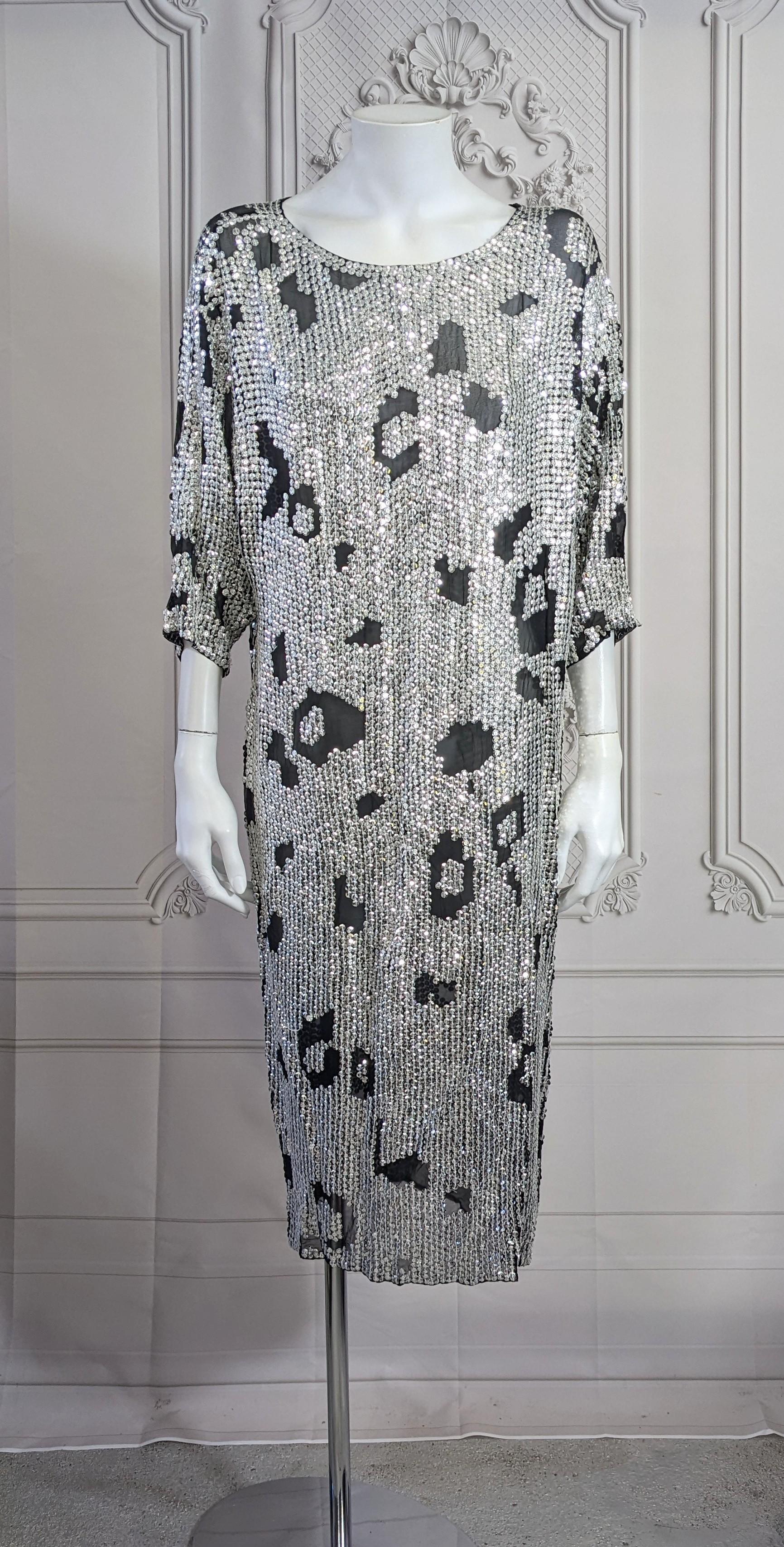 Robe à sequins à motif animal en mousseline de soie noire vendue par Hatties', Chicago, dans les années 1980. Coupe large et surdimensionnée en forme de T shirt simple et allongé. Sheer nécessite une doublure. 1980's.
Taille S Vintage mais coupé