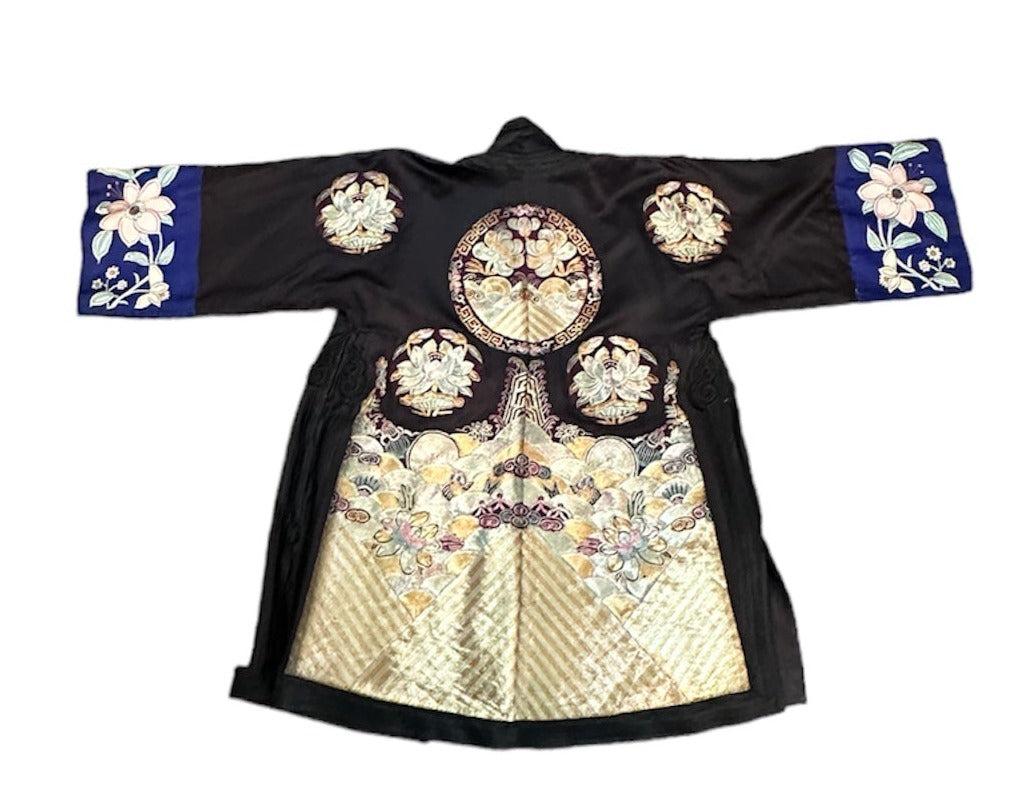 Take a step back in time and indulge in this exquisite 1920s Chinese jacket. The black silk satin is adorned with elaborate appliques and intricate hand-embroidery, creating a stunning piece that showcases incredible craftsmanship. The heavily